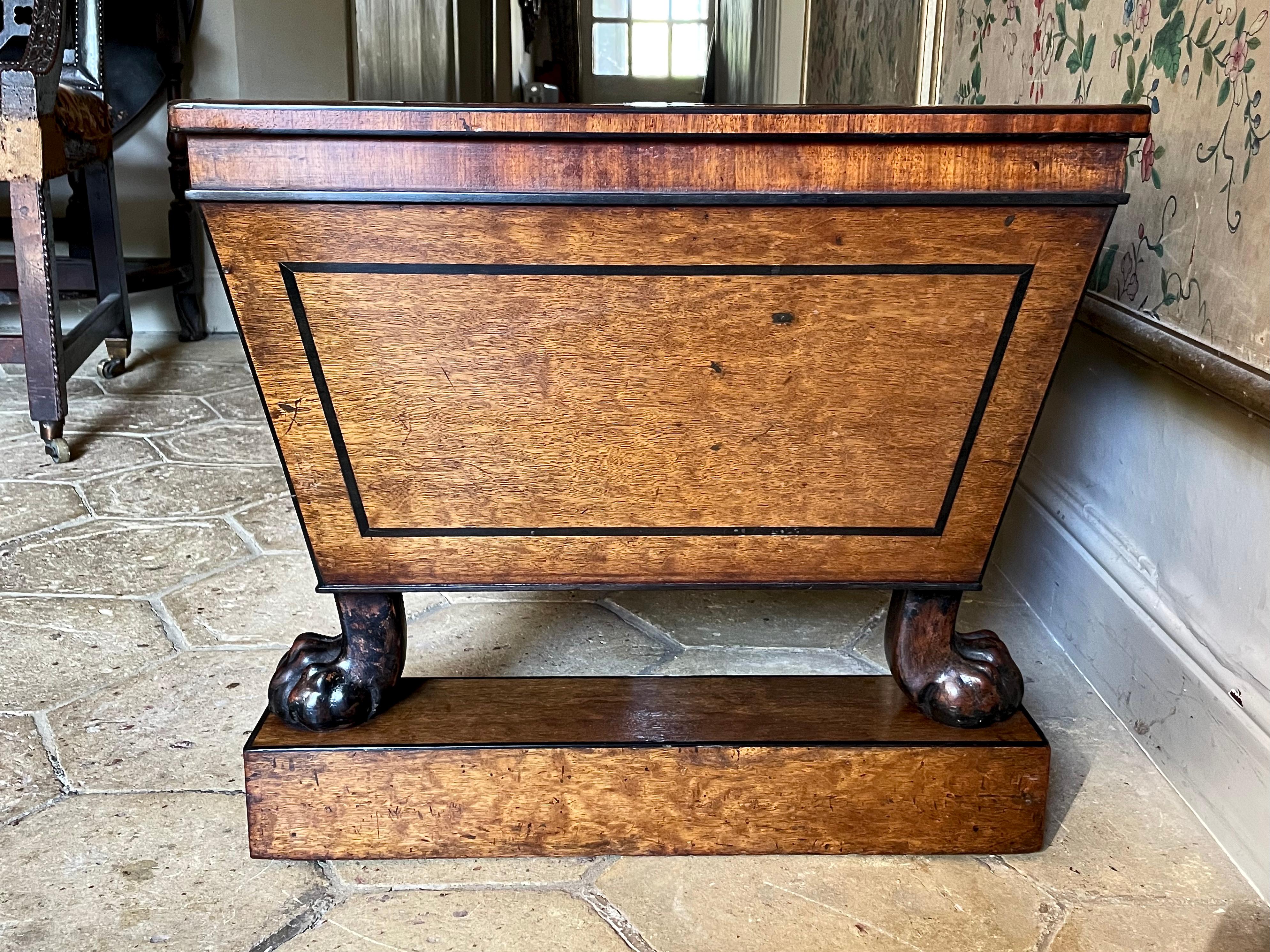 A fine and rare cellarette - or jardinière - attributed to Thomas Hope, ca 1810.

In the best quality mahogany with ebony lines and raised on well-carved animal paw feet. Original zinc liner and removable zinc tray insert. Raised on twin plinths