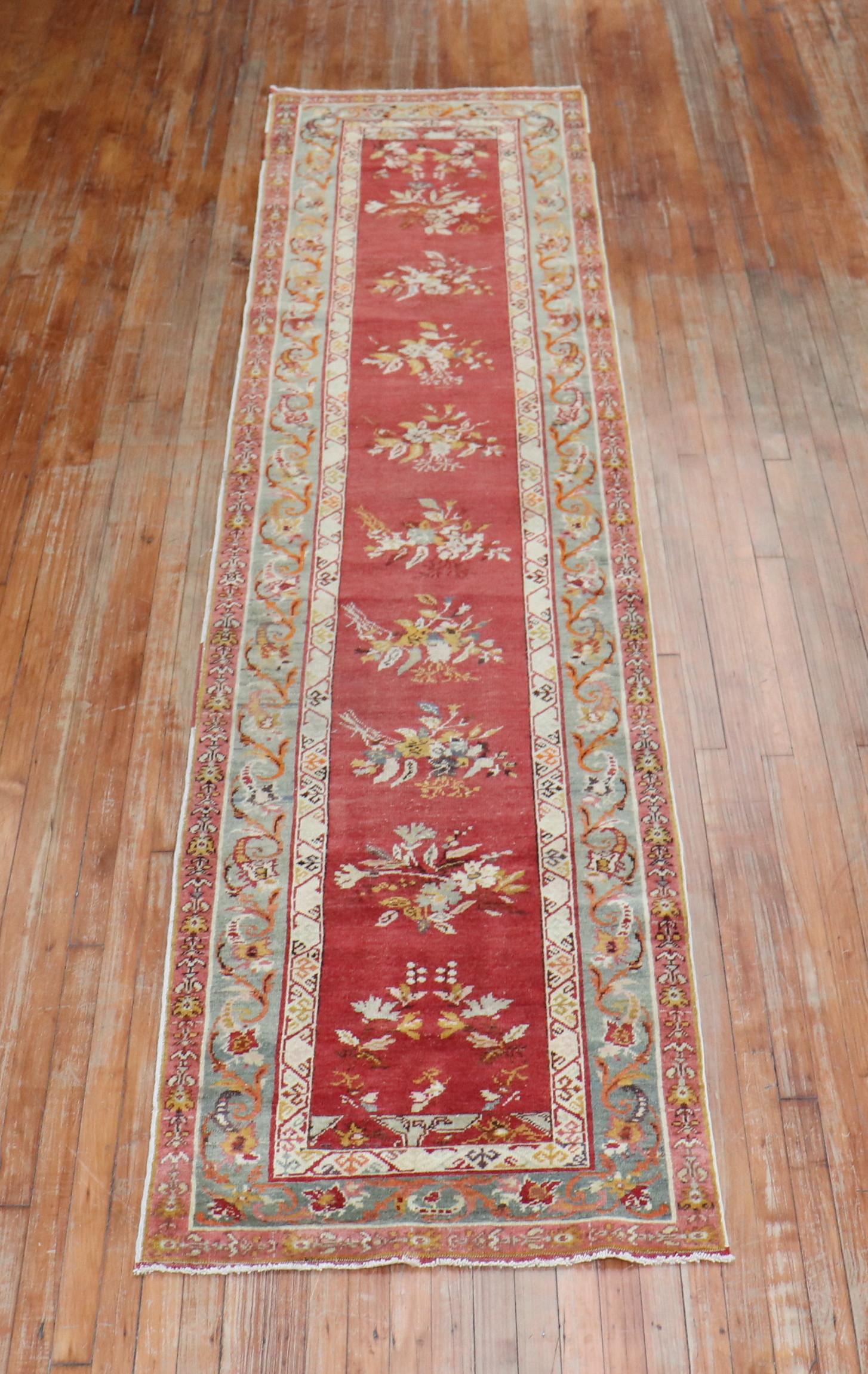 Early 20th century red field Turkish runner with an all-over repetitive flower design on a red field. The border is in green

Measures: 2'9” x 11'6”.