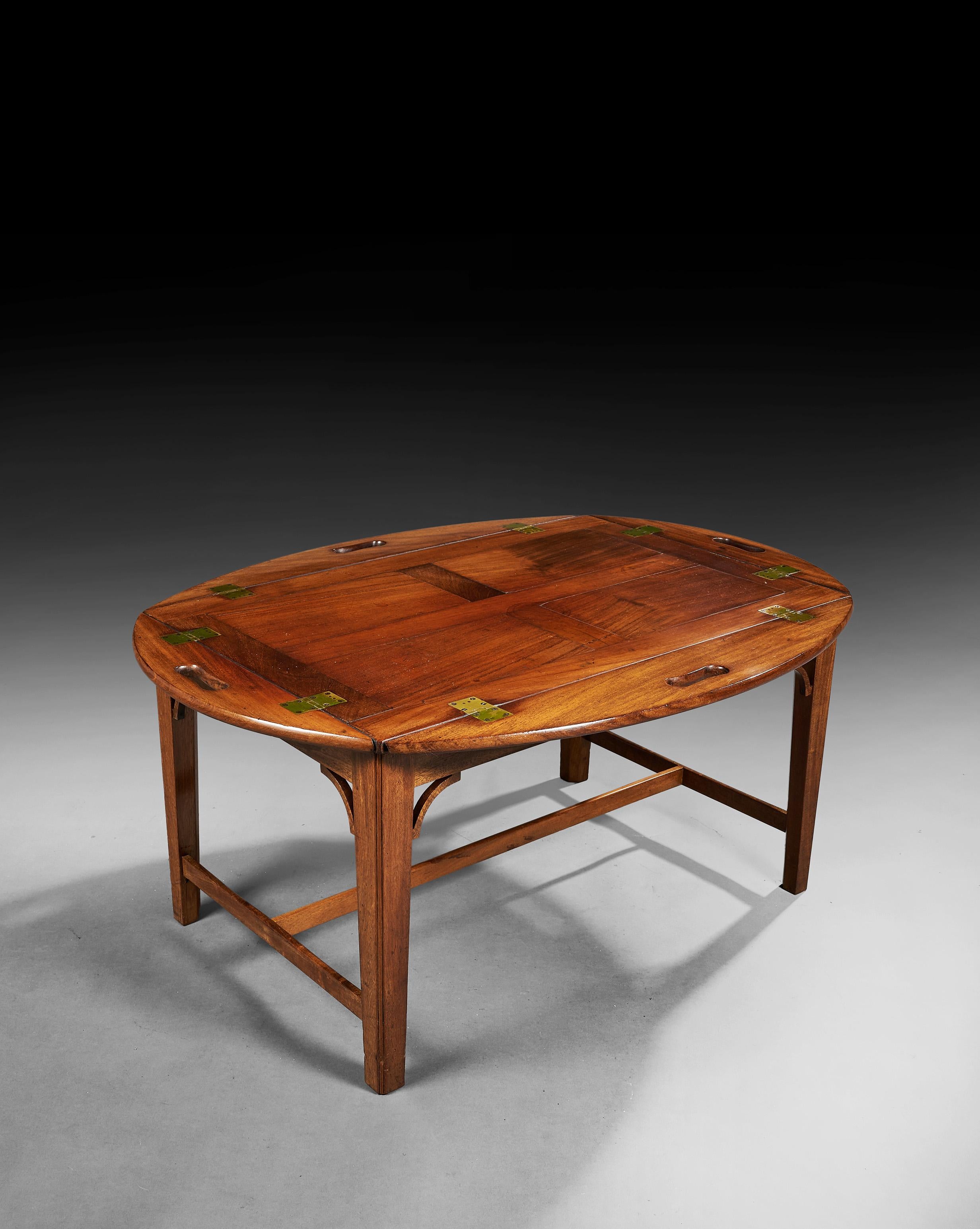 A fine Regency Period Hinged Butlers tray on later stand, ideal as a coffee table.

Regency circa 1810 - Stand circa 1920.

The oval shaped mahogany tray top, of panelled construction and outstanding natural color and original patina, having
