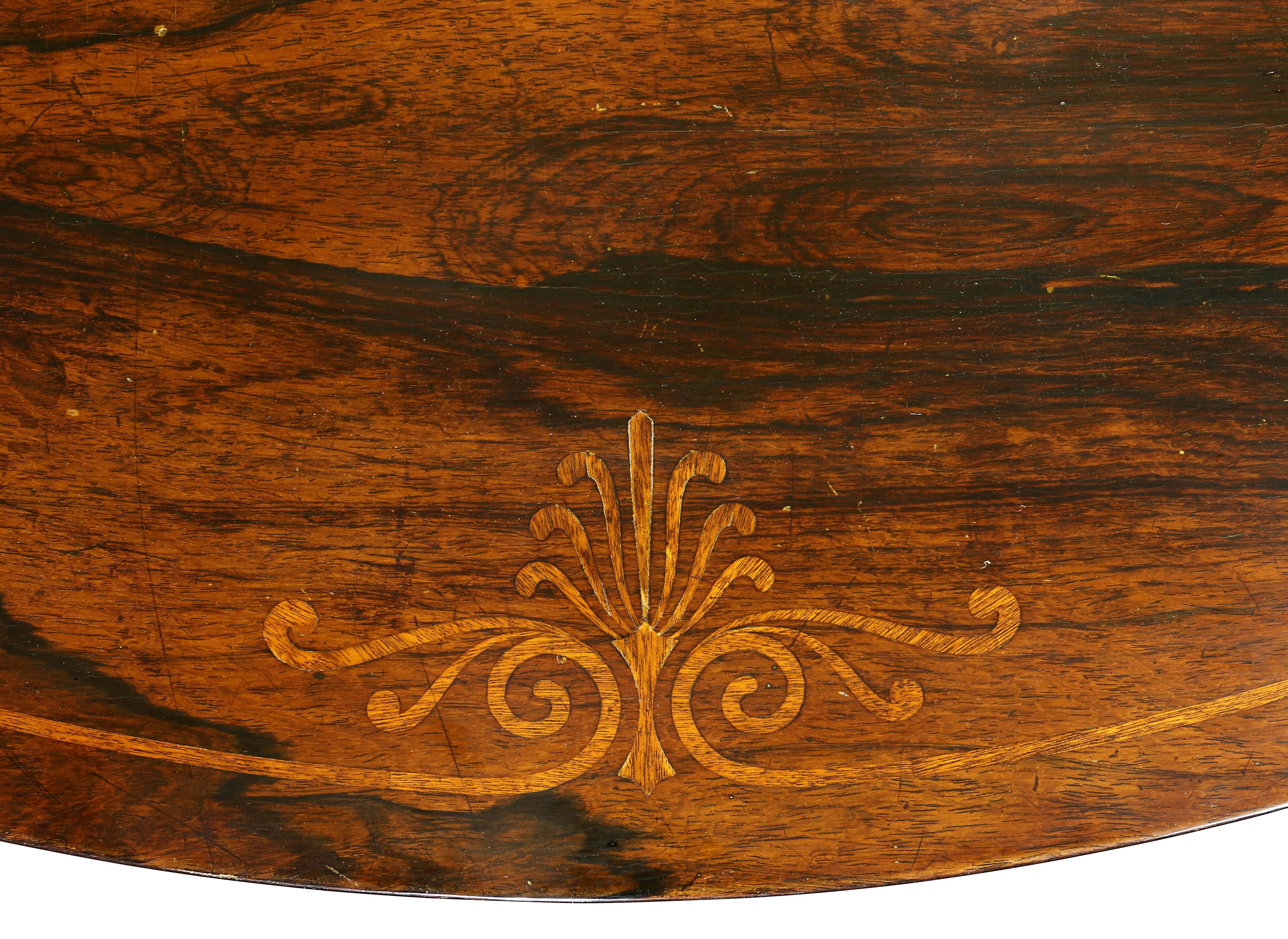 With circular tilting top with anthemion inlay over a frieze with a brass beaded edge, the support partially water gilded with reeded decoration over a tri section base ending on anthemion bronze mounts on scroll feet.