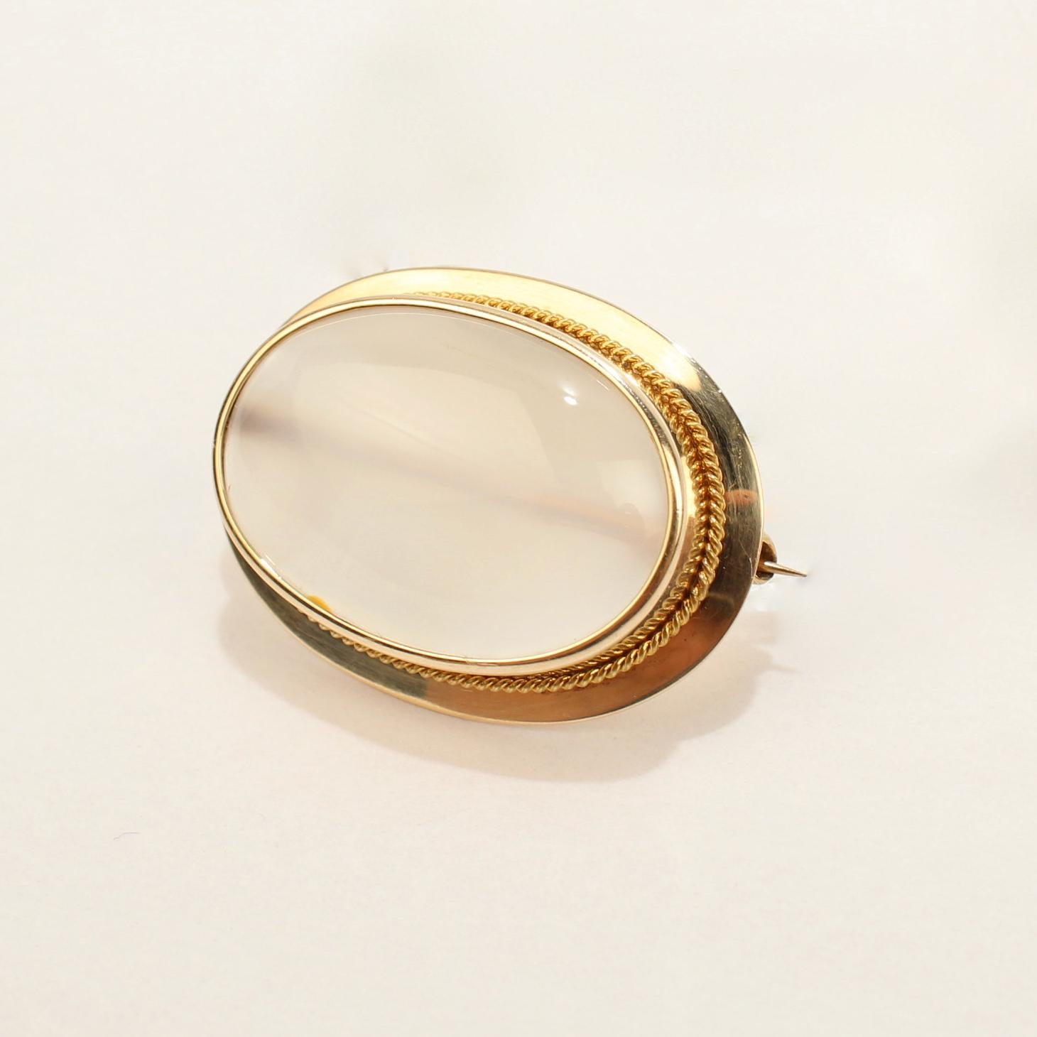 A fine vintage gold and moonstone cabochon brooch. 

With a large moonstone gemstone bezel set in 10k gold.

The finely polished moonstone cabochon has a lovely milky opacity and a small brown inclusion at 7 o'clock on the dial.

Simply a fine retro