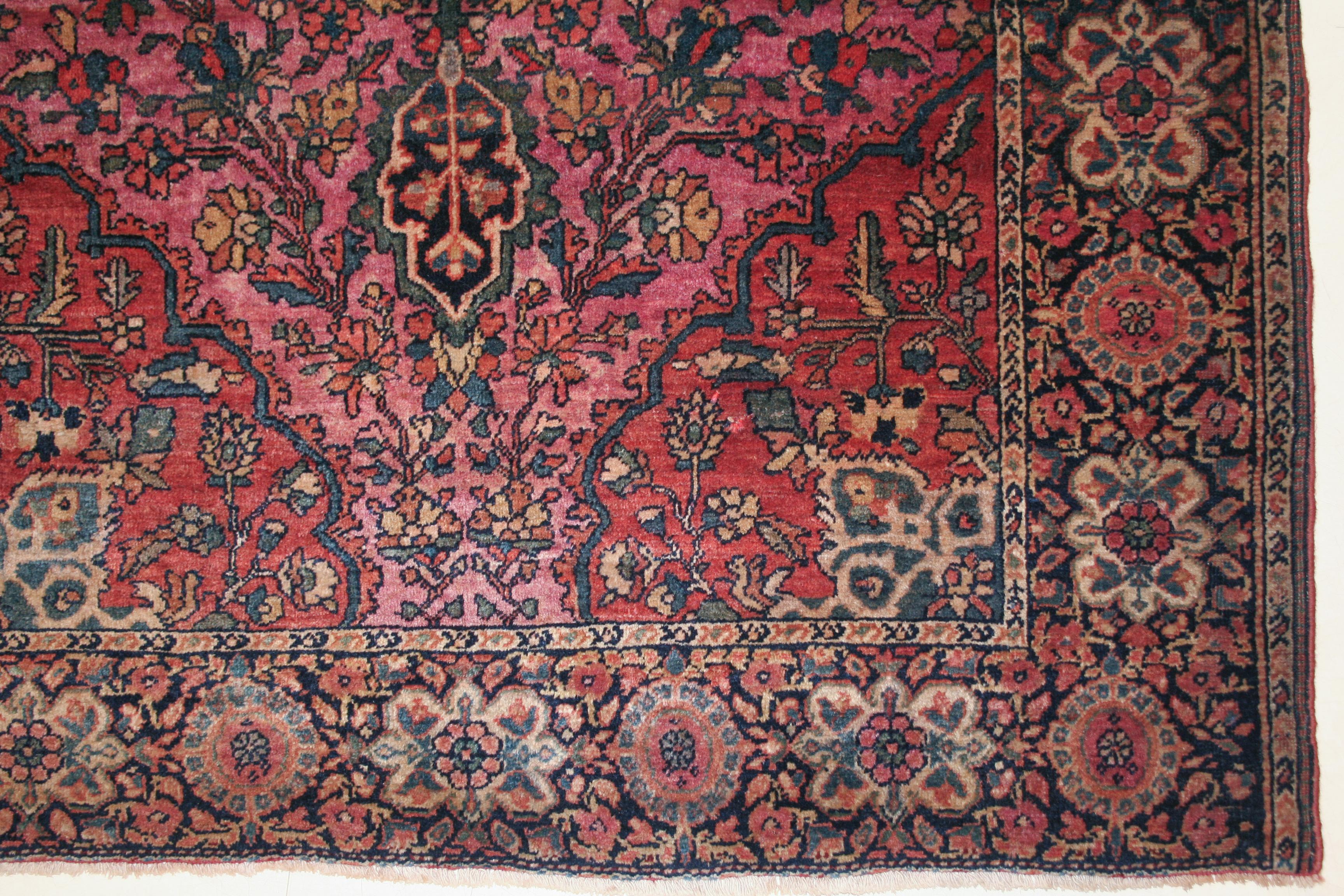 Tapis Sarouk Ferahan très finement tissé, décoré d'un motif de médaillons et de pendentifs sur un fond rose foncé. Les sarouks de Ferahan sont représentatifs d'un groupe classique d'exemples de motifs persans du début du siècle provenant de la