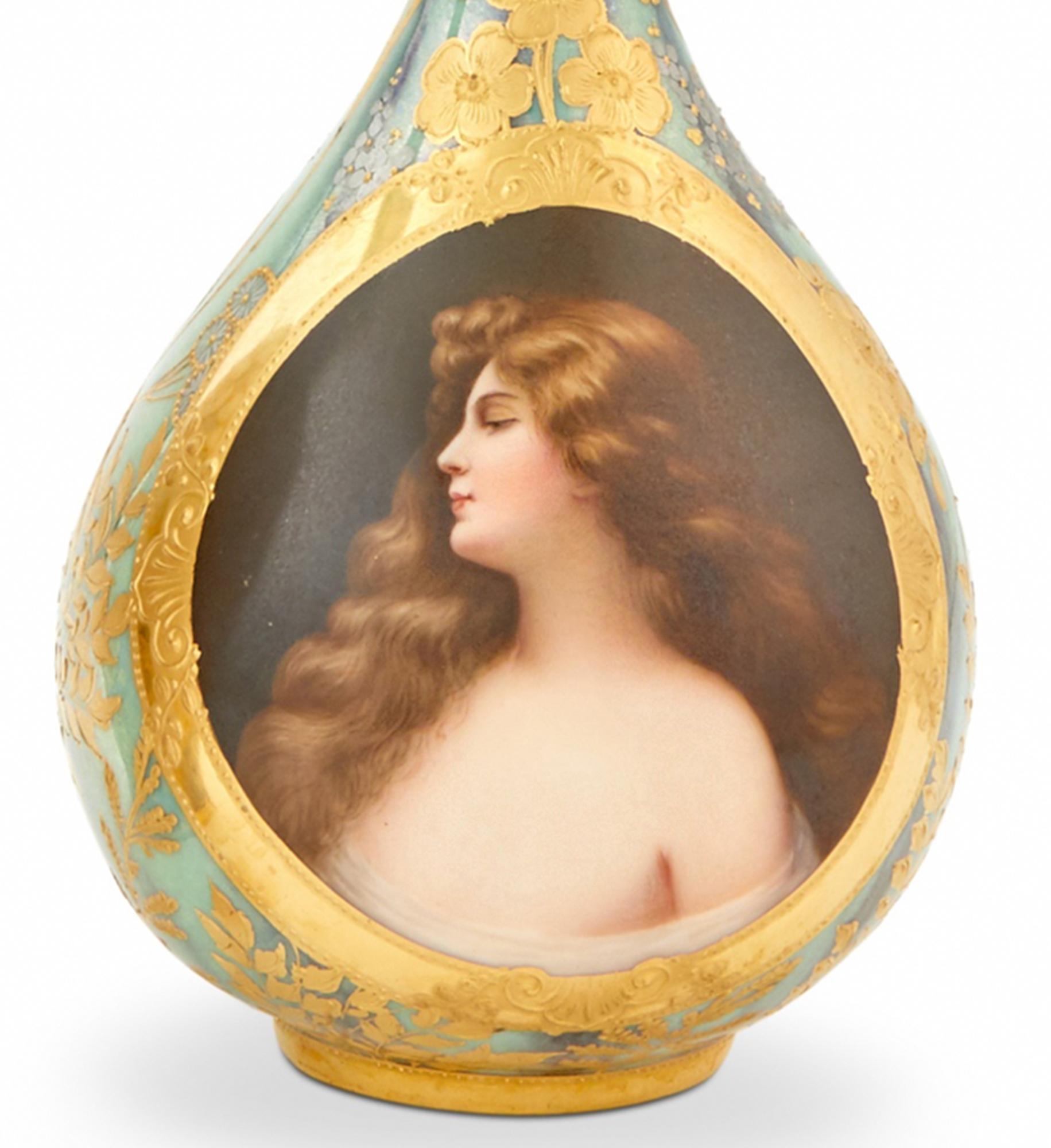 Fine royal Vienna portrait vase of a soft faced beauty with cascading wavy hair, brown eyes and a neutral expression is encircled by a band of polychrome gold paint with raised painted ornaments. Blue from the neck flows downwards, diffusing into a