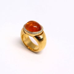 Anello in oro rosa con 1 granato mandarino cabouchon e diamanti