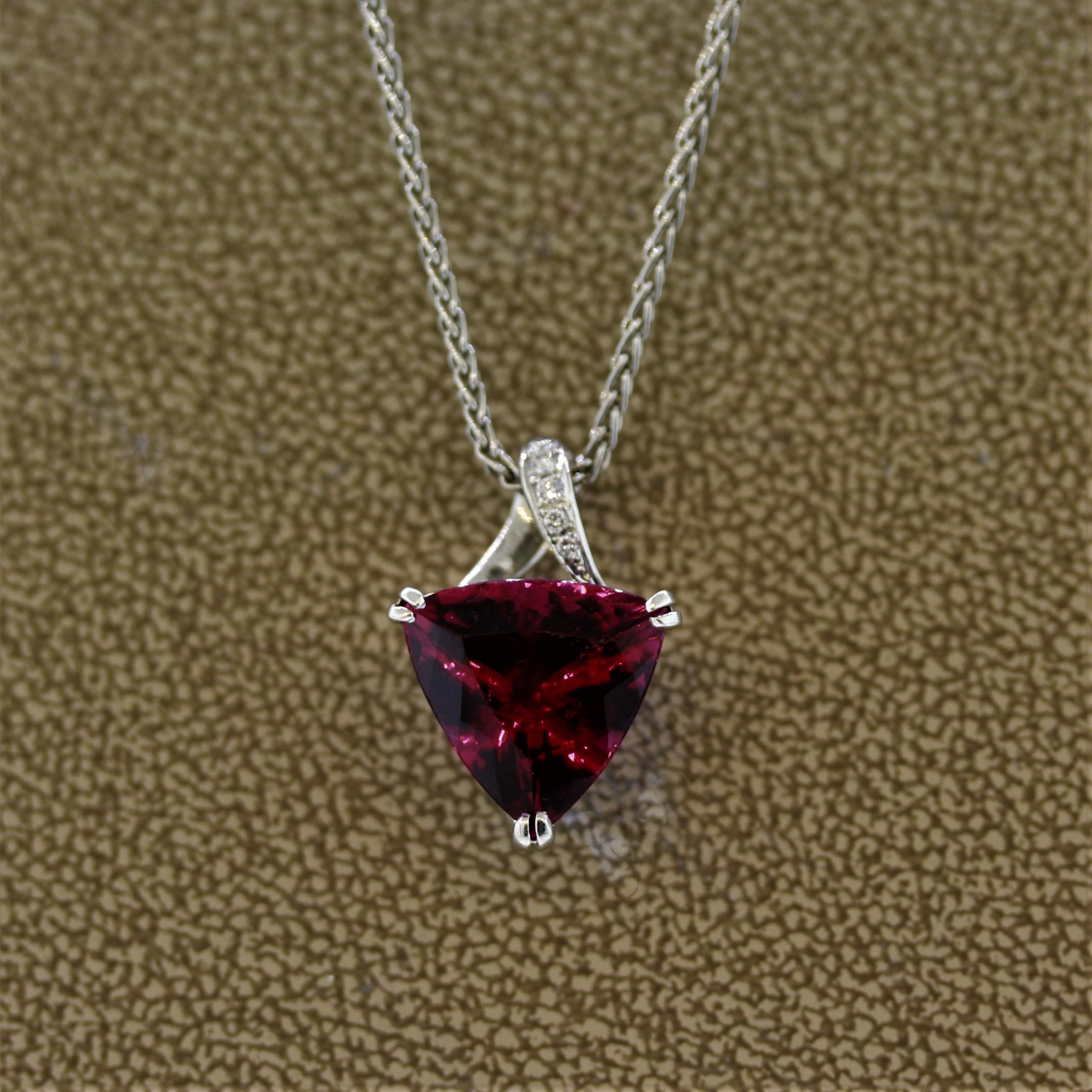 Here we have an excellent example of a fine gem quality rubelite tourmaline. This triangular cut gem weighs 5.50 carats and has a bright vivid pinkish-red color with fantastic brilliance. It is accented by 4 smaller round brilliant cut diamonds set