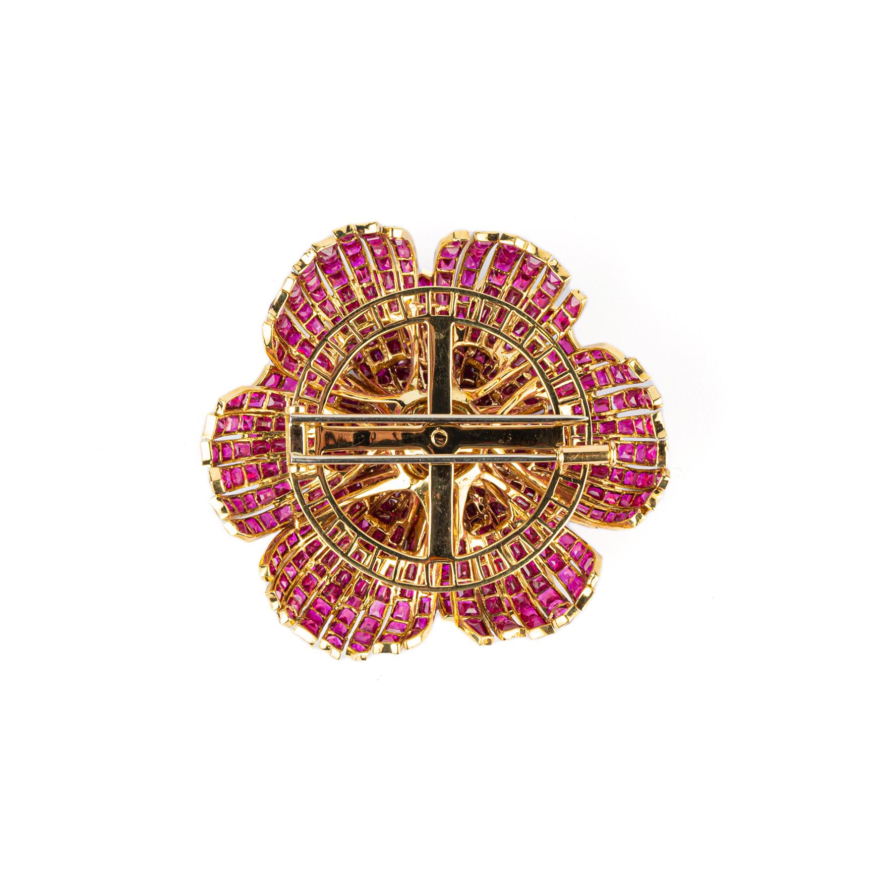 An Exquisite Flower Brooch with carrè set rubies, centering an Old Cut Diamond (1.5-2 cts) mounted in 18k Yellow Gold. Made in Italy, circa 1965. 