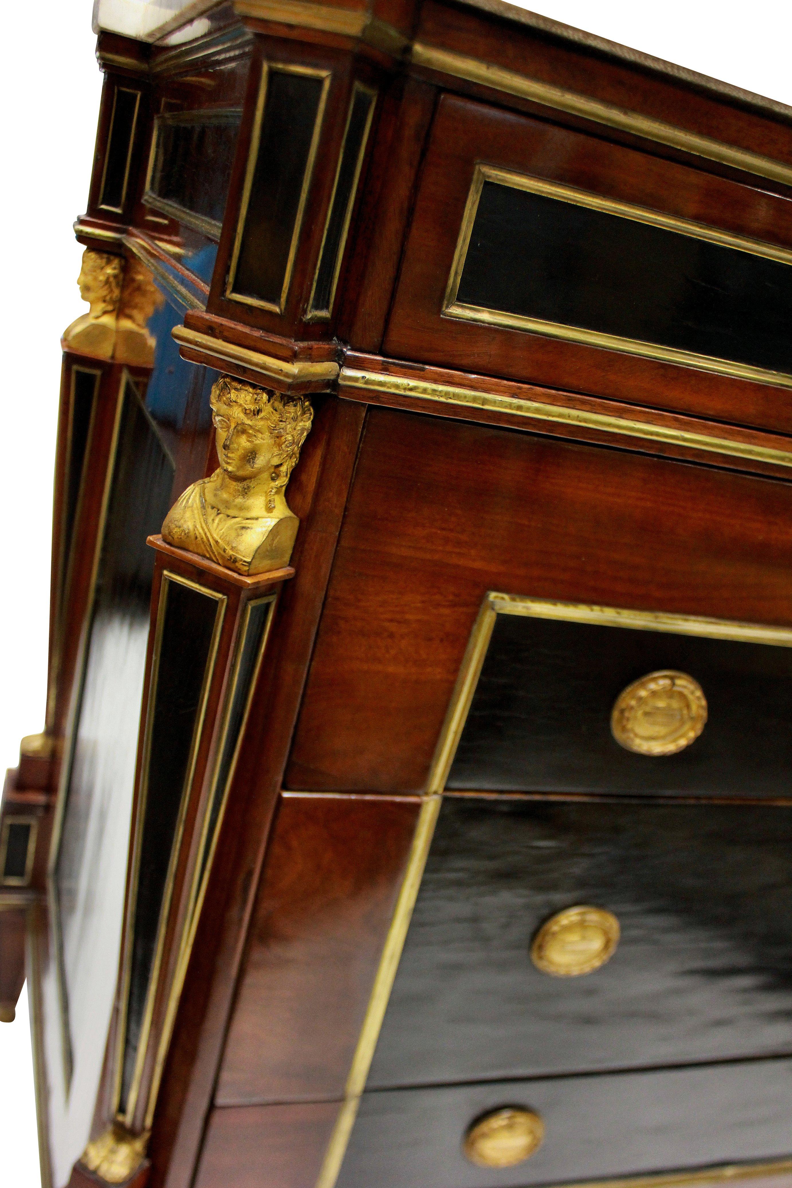 A fine Russian 18th century commode in mahogany, with ebonized panels edged in gilt brass. With classical gilt bronze caryatids and lion paw feet. Each drawer with the original locks and a handcut dove grey veined marble top.