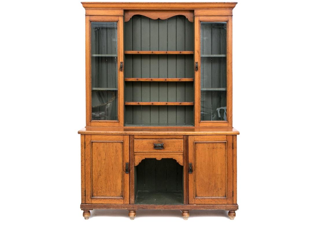 A large and very well crafted Rustic Breakfront in a handsome Amber tone stain. With plenary of storage and display space including two glass door fronted shelf spaces, middle display shelves with 12 mug hooks on top and the base with a central
