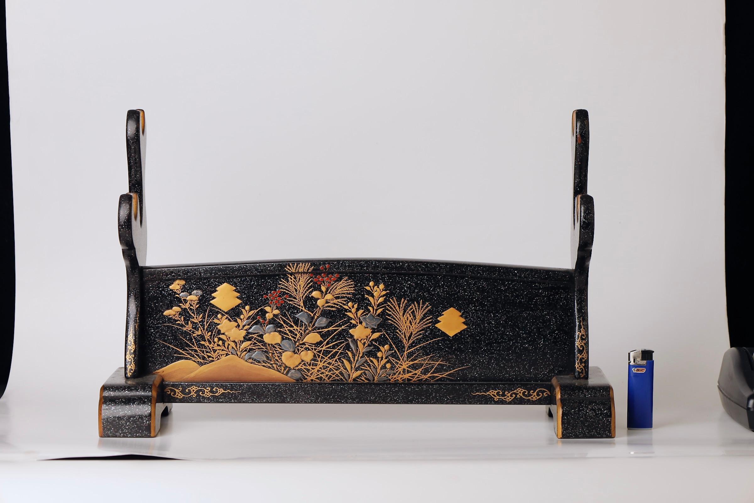 A refined katana stand from the late Edo period (circa early to mid-19th century), featuring elegant makie (蒔絵) lacquer decoration in gold and black. Crafted to display a samurai’s cherished sword with honor and dignity, this stand exemplifies the