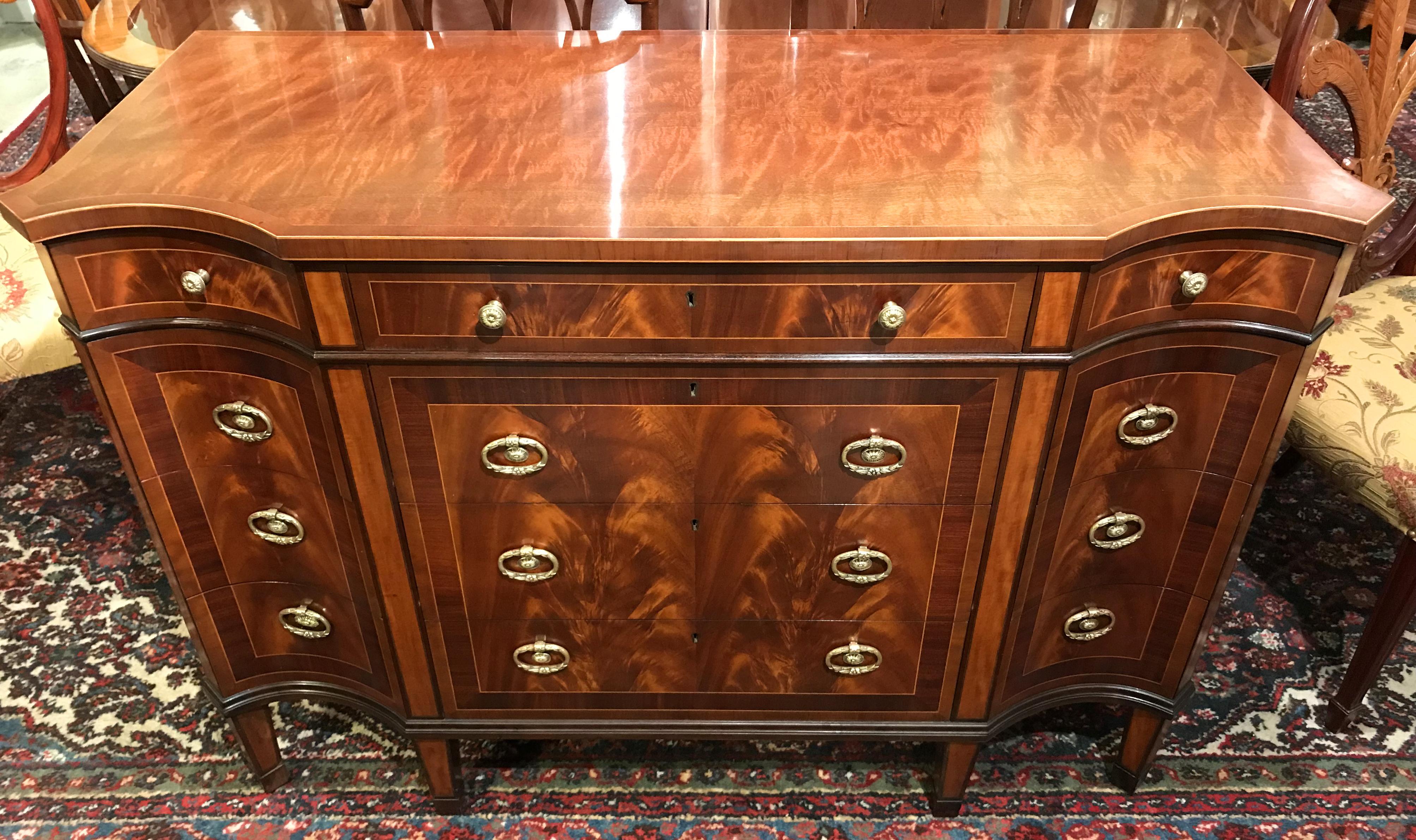 An exceptional custom made chest of drawers or sideboard by Schmieg & Kotzian of New York, with conforming top surmounting three fitted frieze drawers over three long drawers flanked by three fitted conforming drawers on each side, all with