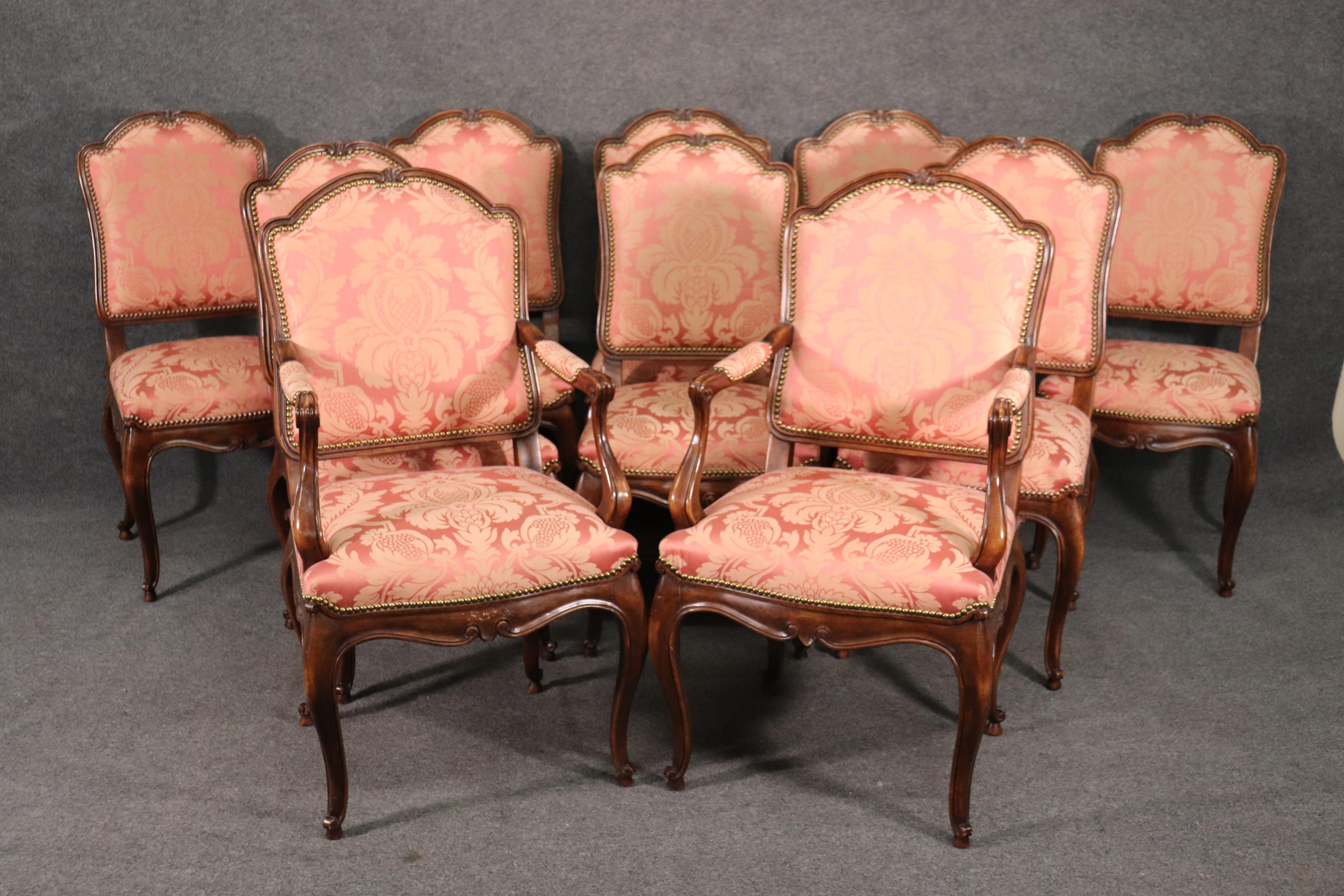 This is a fantastic set of 10 beautifully upholstered and trimmed in nailheads. The frames are beautiful quality with nice precise carving. The blush pink damask upholstery may be silk but I can't say with absolute certainty but its clean and still
