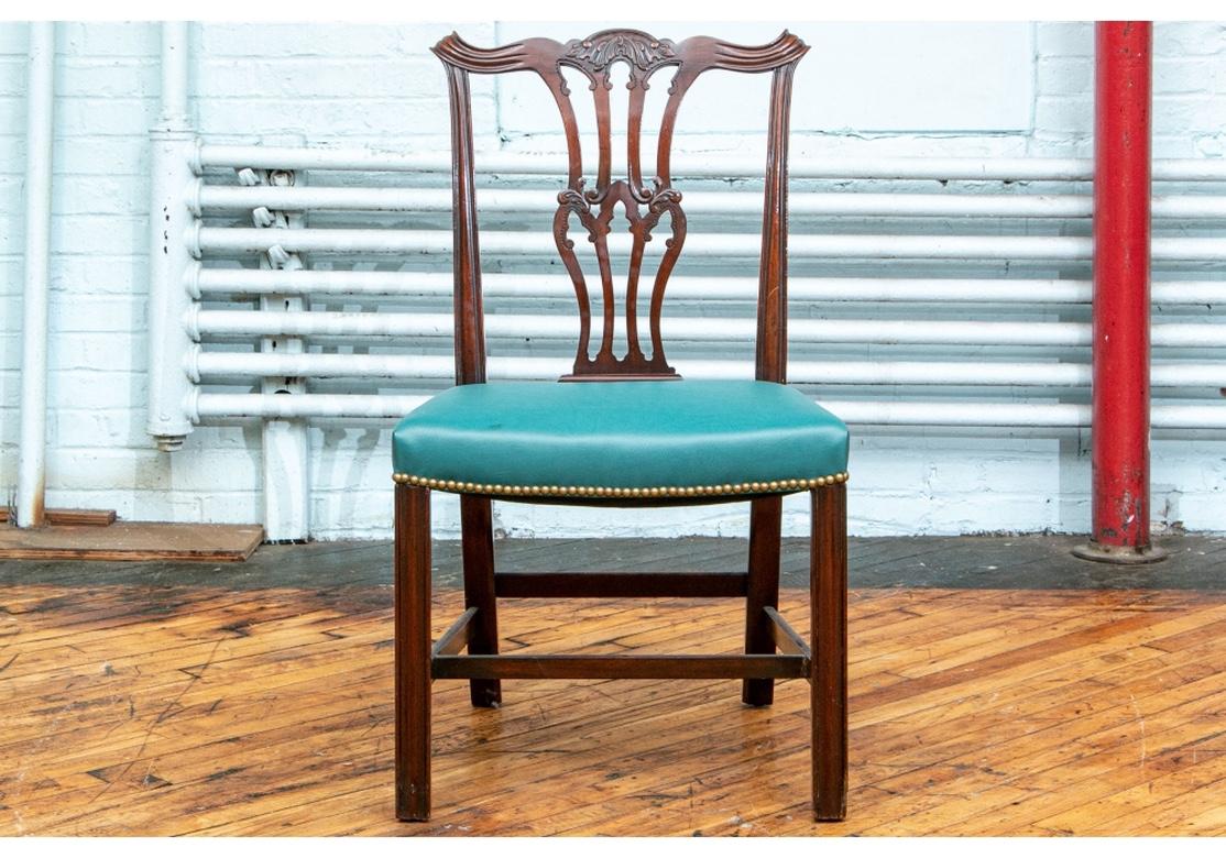 Fine set of 10 Chippendale style mahogany dining chairs having green leather or leatherette upholstery, 3/4 surround nail-head trim, straight fluted legs, cross stretcher base. Very stabile and quite comfortable. 
Dimensions:
Arm chair: 27