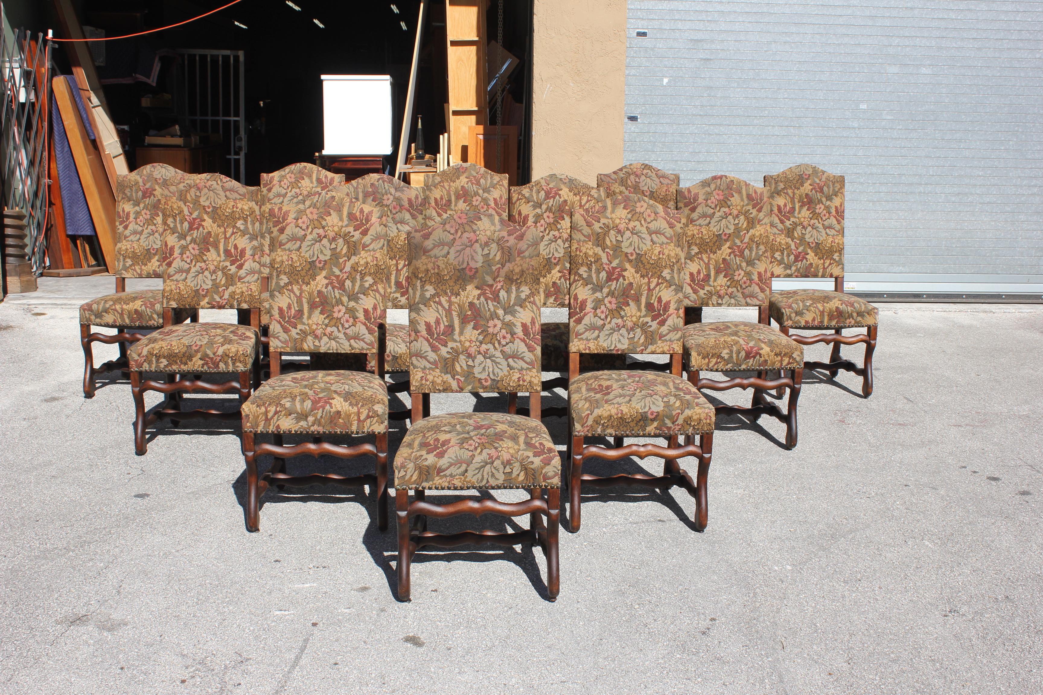Fine set of 12 Louis XIII style Os de Mouton dining chairs with chapeau de gendarme backs, circa 1900th century. Vintage fabric upholstery with nail heads, the solid walnut chair frames are in very good condition. From South France. (fabric