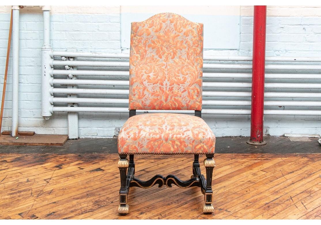 A superb set of 12 Louis XVI style dining chairs with high shaped backs having a carved and ebonized frames and legs. Fluted tapering legs with gilt tops and feet and fine scrolled H-stretchers. Upholstered on the front and seats in a coral/gray