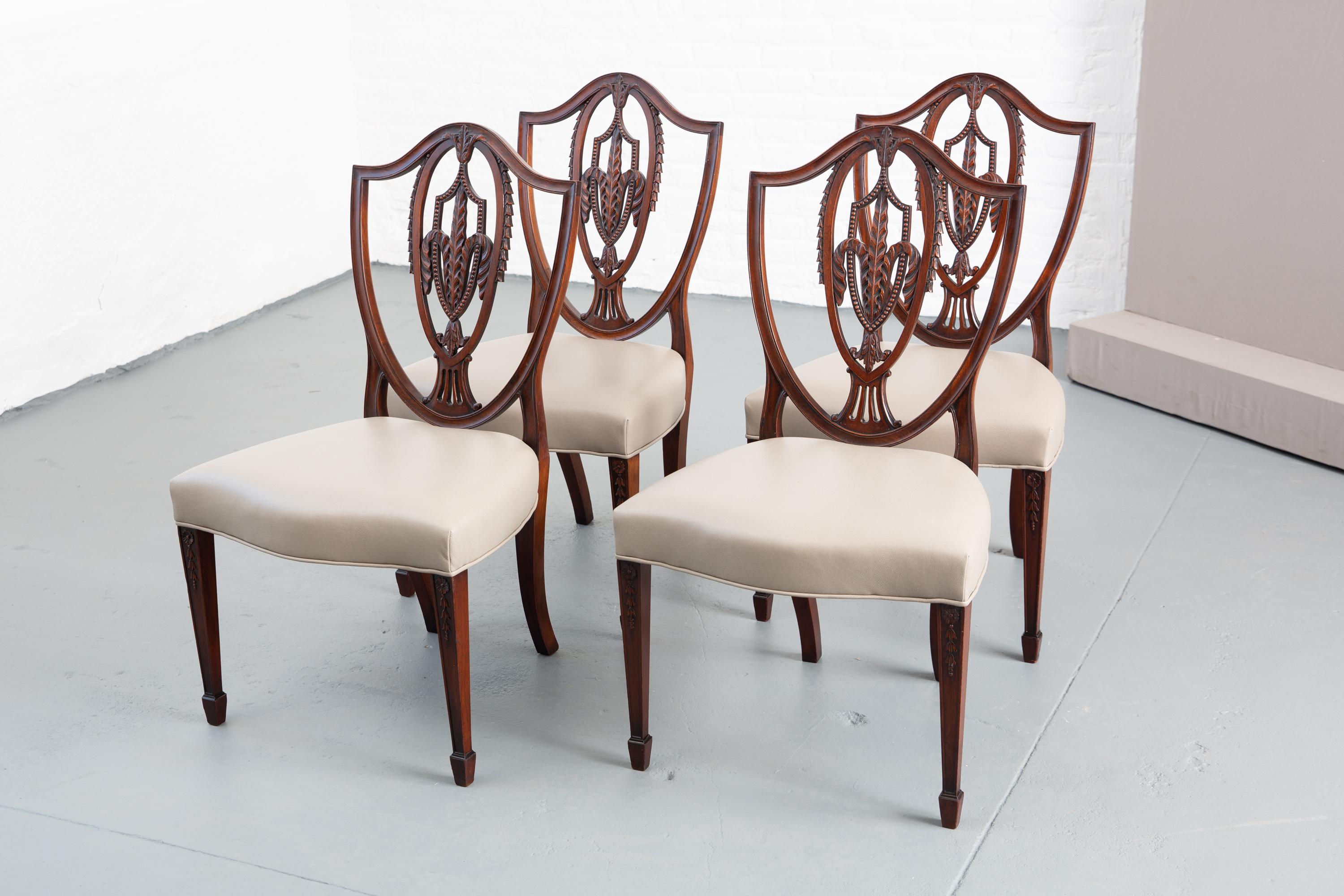 Set of 4 newly upholstered Federal Hemplewhite style dining chairs with shield back. Carved wood back and high quality Holly Hunt leather to the seat. Single welting.