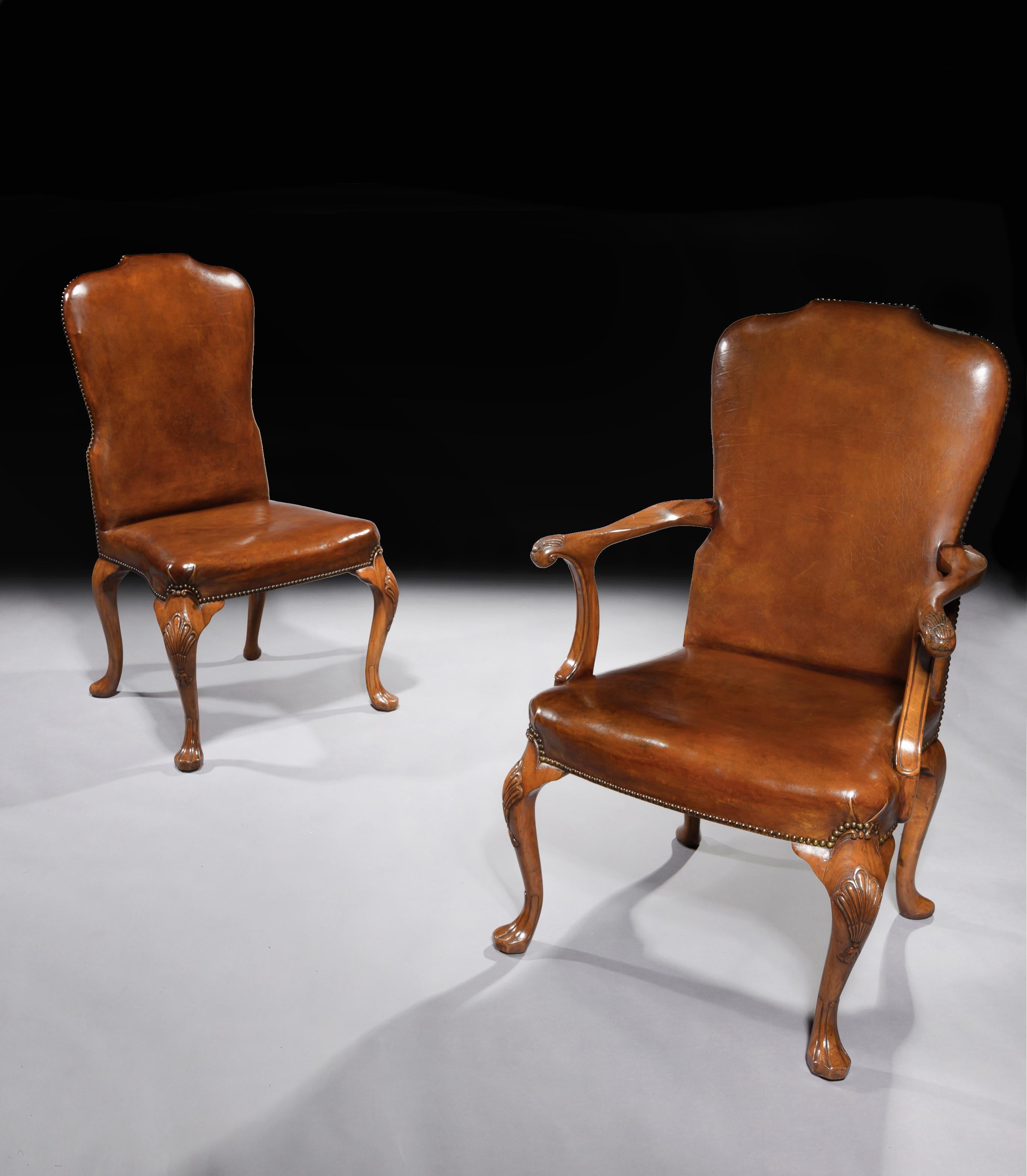 A superb set of eight walnut cabriole leg dining chairs in the original leather upholstery.

English, circa 1910-1920.

Generously sized and designed in the George II style, having a raised shaped and waisted back over a stuff-over seat with