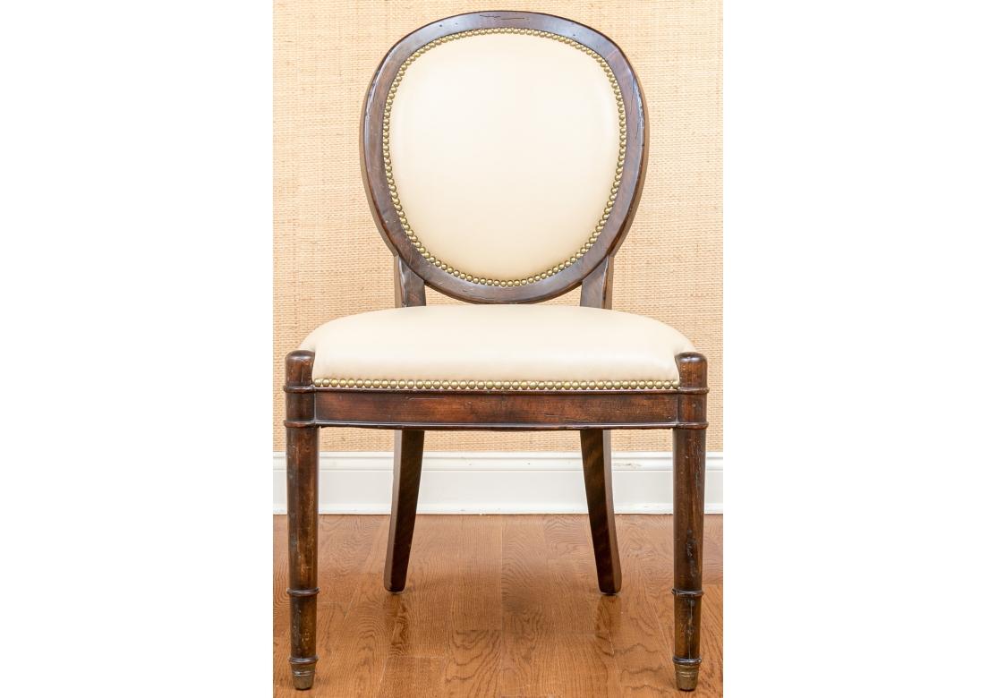 A contemporary take on Classic French design, this elegant set of Eight Dining Chairs are very well made, sturdy and exceptionally comfortable. The set features dark stained Hardwood frames having Oval backs, turned and ridged front legs,