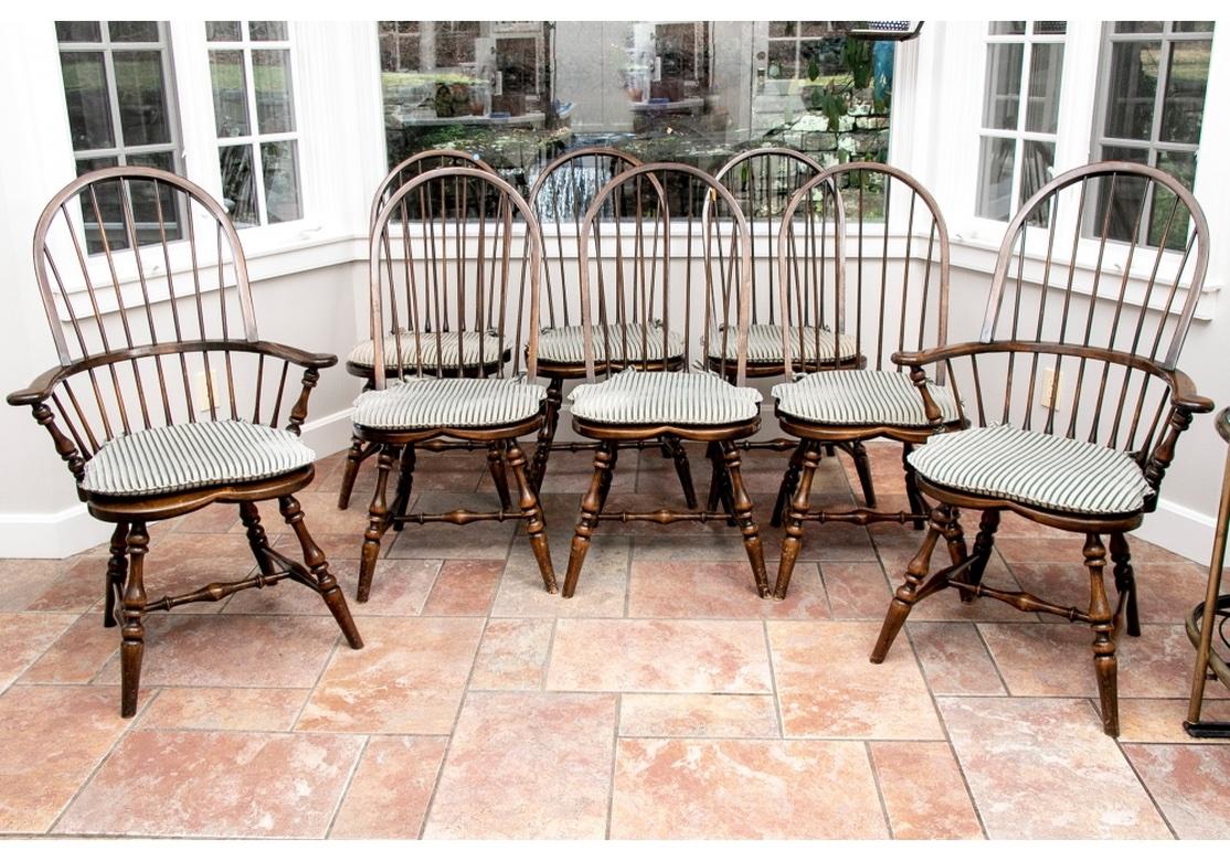 A fine set of very well made Windsor Chairs with good traditional form. Including two arm and six side chairs in a medium brown glossy finish. With the classic hoop and spindle backs, scrolled arms ends and turned legs and stretchers. Along with