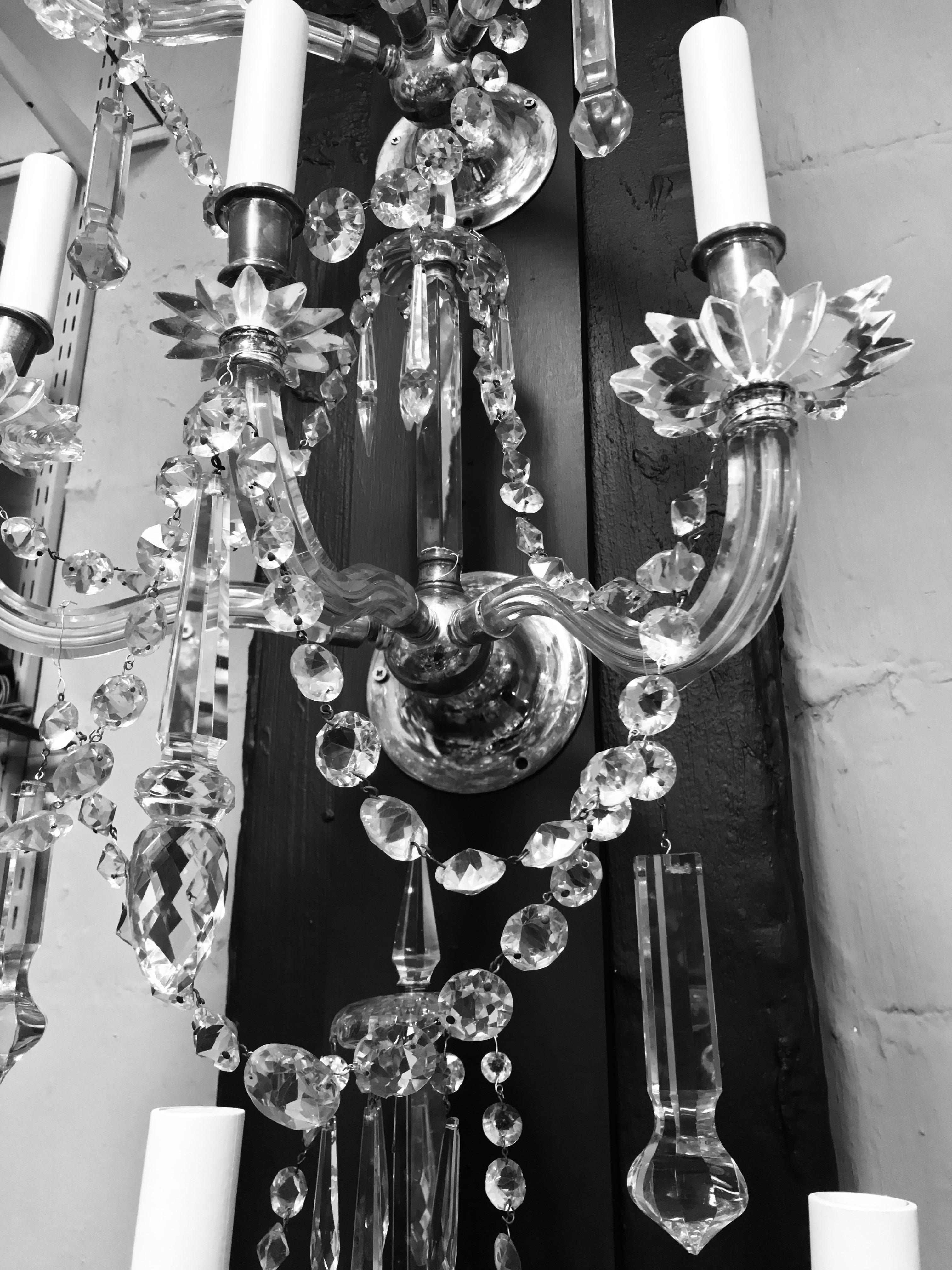 A fine set of four English cut-glass, three branch wall sconces. Beautifully hung with swags and spires.
  