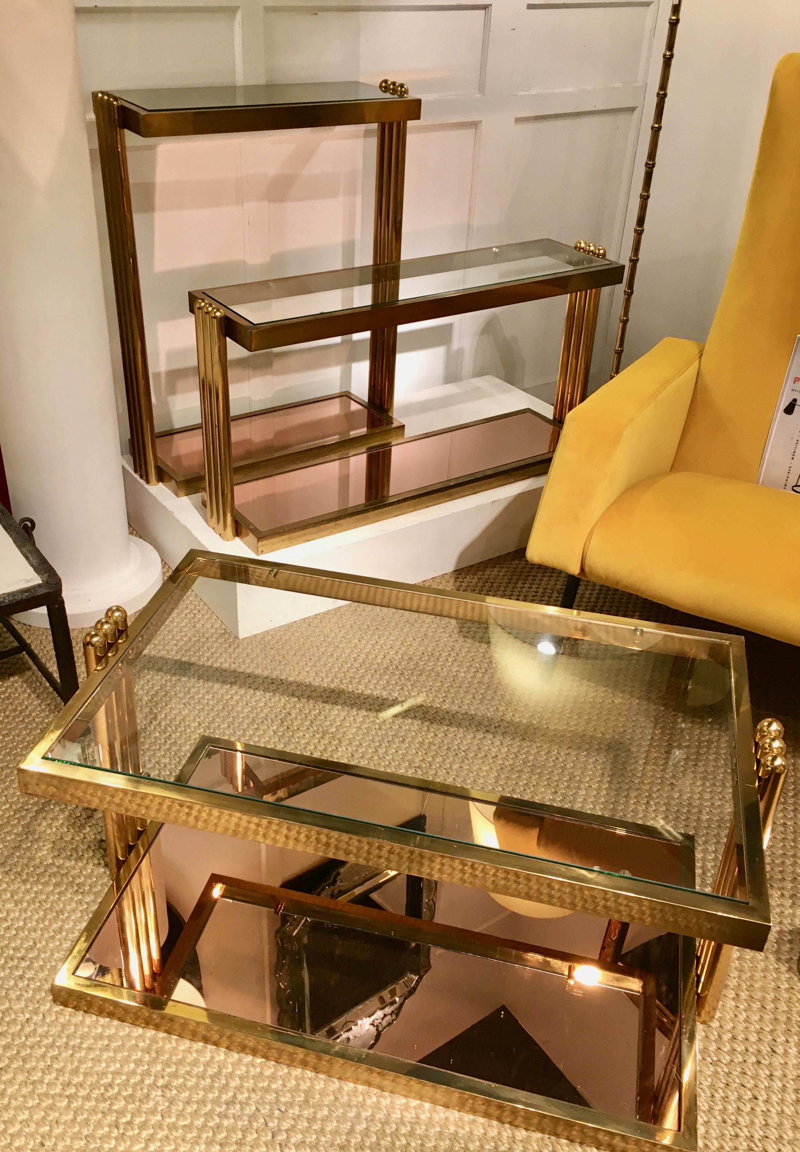 Heavy massive brass tables (two) and a small console table.
Two--tiers with clear glass tops and a mirror at the base supporting by three tubular pieces on each side.
By Nucci Valsecchi, Italy 1975.