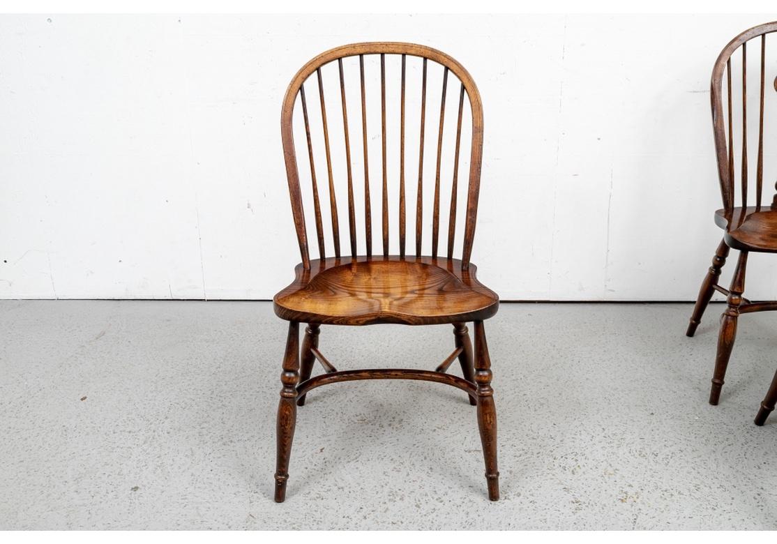 A particularly well made set of stained hardwood windsor chairs, likely Ash,  consisting of five side and one armchair. Made in England with classic saddle seat, turned legs, u form base stretcher, handsome wood grain and traditional pierced back