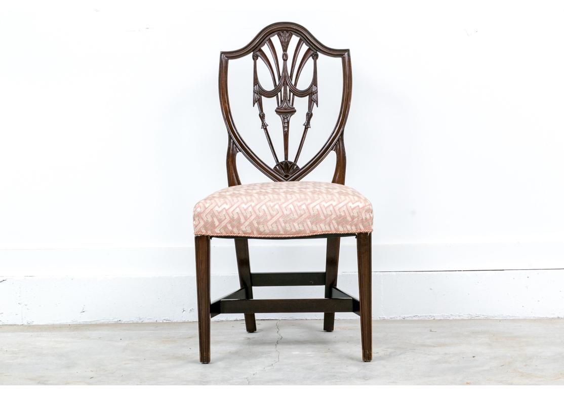 Un conjunto de sillas de comedor Shield Back muy bien hechas y con una sensación de solidez, con armazón de caoba y tapicería a medida. Los bastidores tienen un elegante respaldo con una cresta de plumas y borlas y guirnaldas laterales, patas