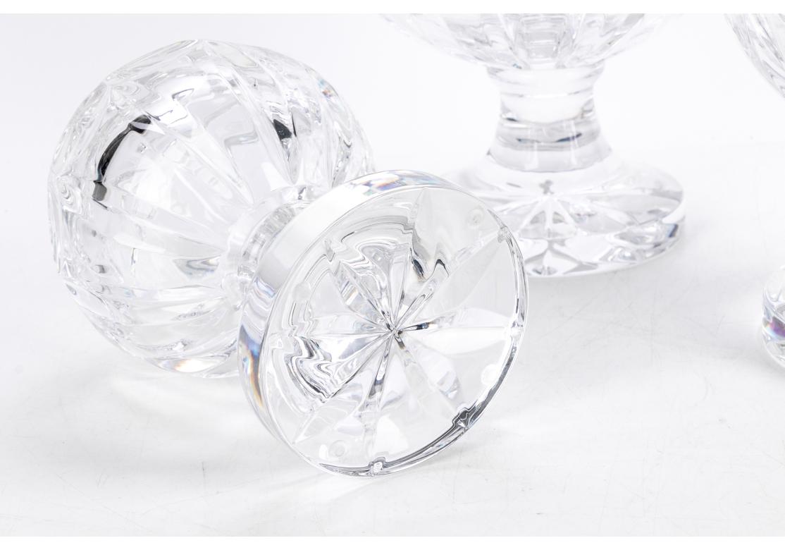 Fine set of three cut Crystal graduated globes on pedestal stands. Each with a cut star form top and optic roundels around the sides. Faceted all around and mounted on pedestal bases with cut motifs underneath. 
H. 10, 13, and 14