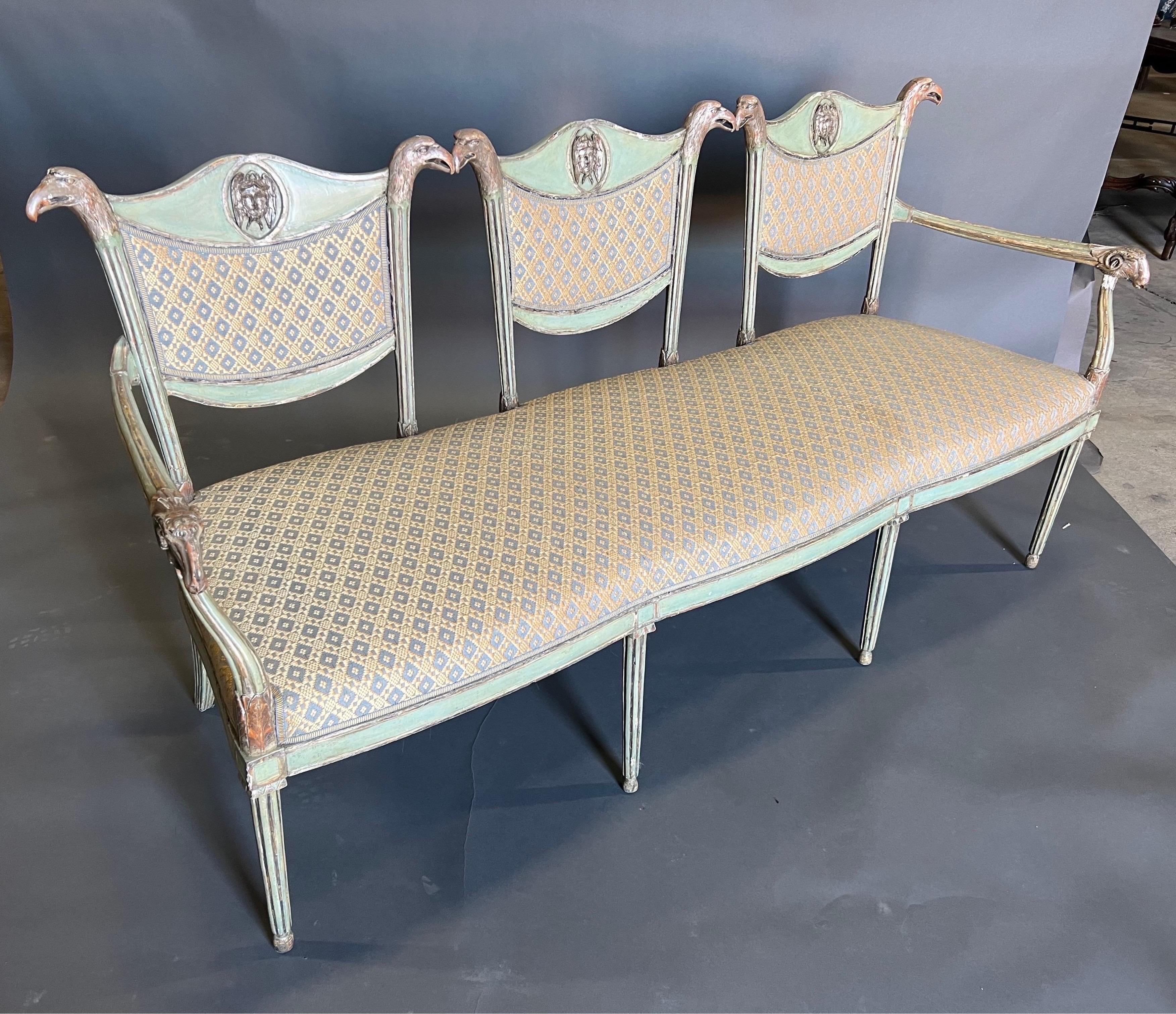 Gorgeous carving and silver leaf on the eagles and rams heads of this fine 19th century French or Russian Neoclassical settee. The light green paint is soft enough and compliments the silver leafed eagles and rams heads. The rams heads finish the