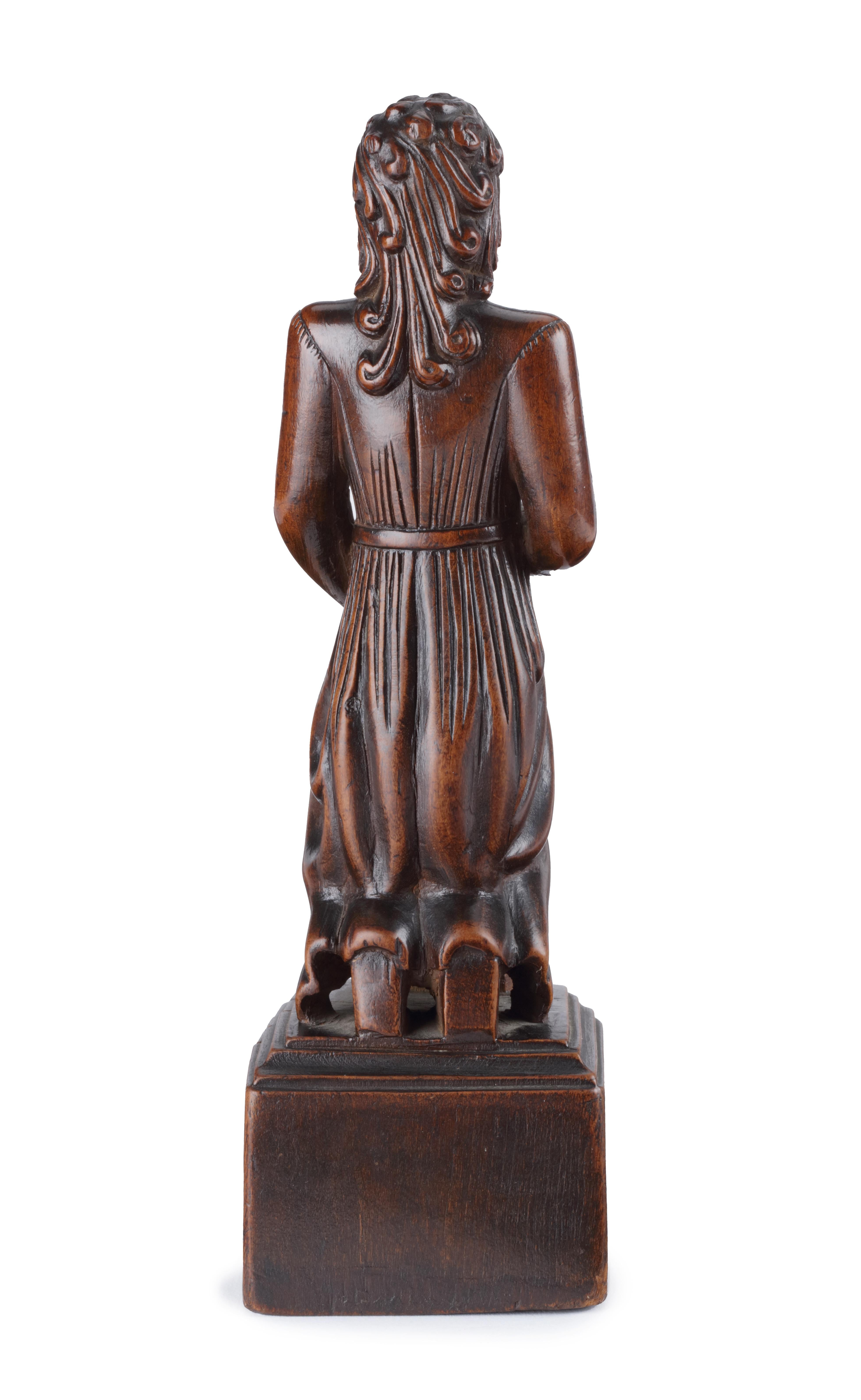 An early Chinese wood sculpture of a Portuguese or Spanish Jesuit

Possibly Macao, 17th-early 18th century, indistinctly inscribed at the front of the base

Measure: H 22.6 cm

The figure, carved in East-Asian walnut with a deep-brown aged