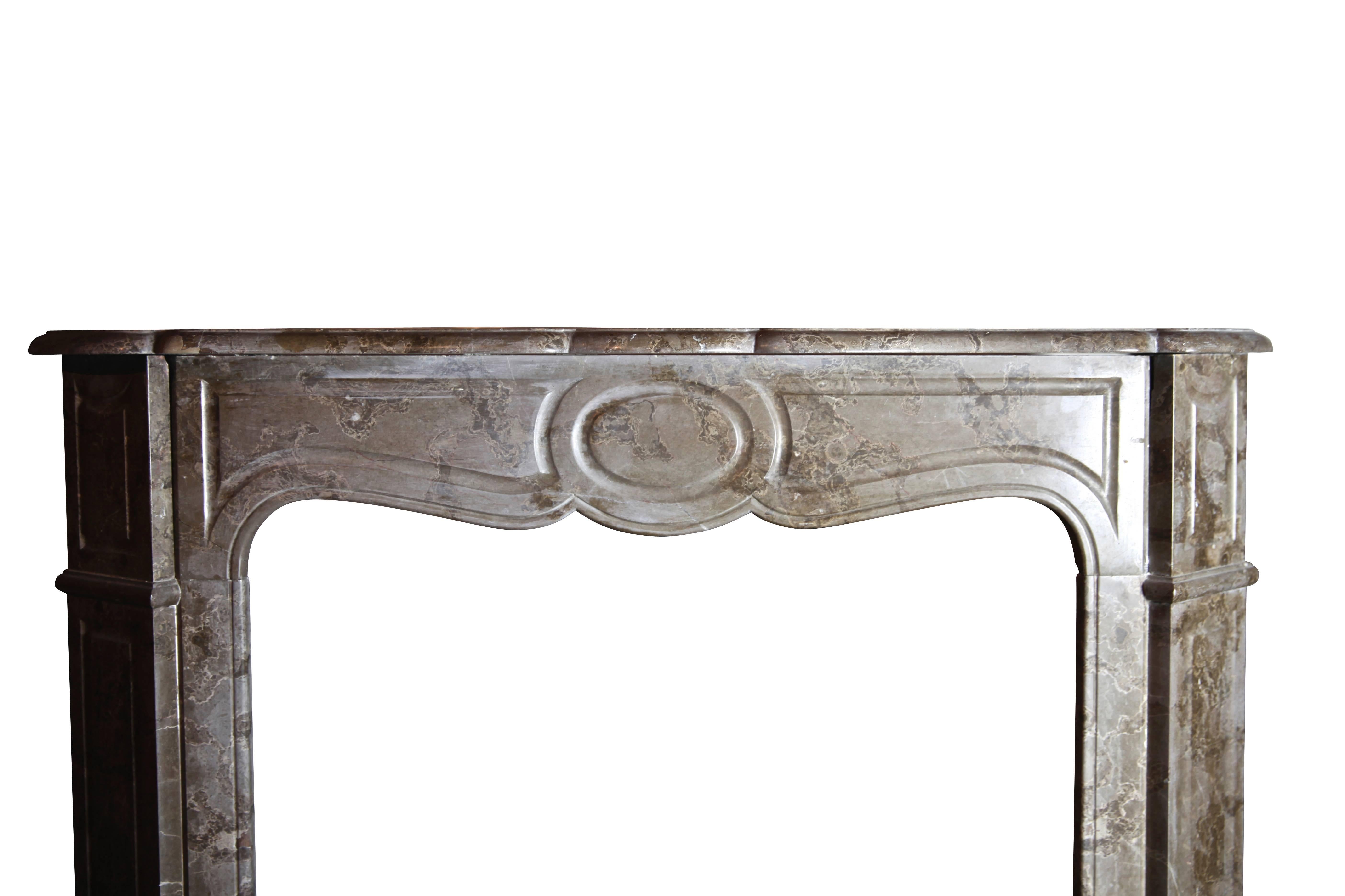 This is a petite antique fireplace surround from a Parisian apartment in the Pompadour style. The marble has a nice oxidation. A perfect fit for a small room, bedroom, library with a French touch.

Measures: 
103 cm Exterior Width 40.55 Inch
100 cm
