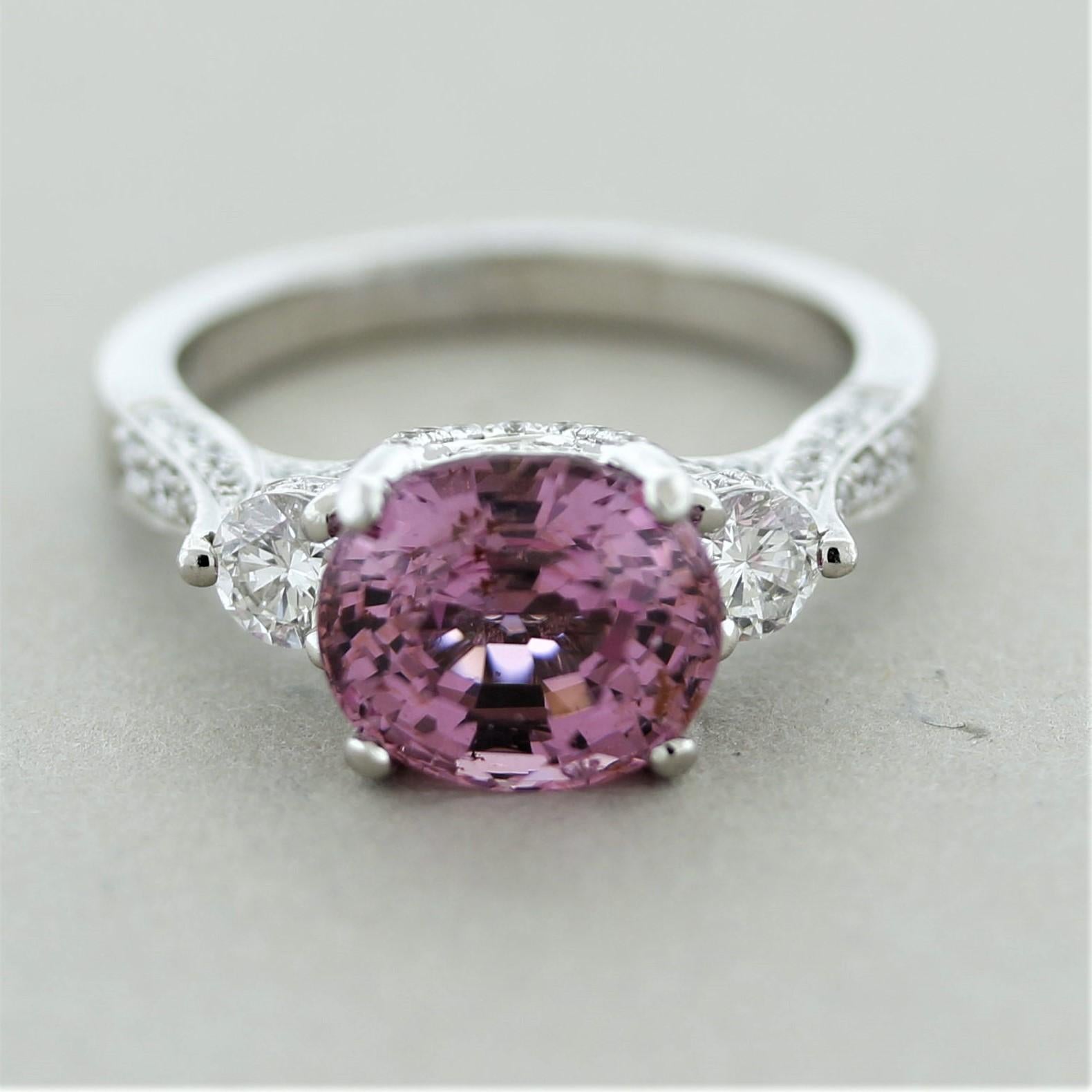 A sweet ring featuring a fine gem 3.86 carat spinel. It has a strongly saturated pink color with exceptional brilliance and dispersion seen in top spinel. It is accented by 2 larger round brilliant-cut diamonds set on its sides along with smaller