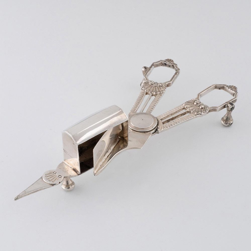 Titolo: Taglia stoppino in argento sterling con decorazione a ventaglio
Data : Punzonato a Londra nel 1789 per Wilkes Booth's
Periodo : Giorgio III
Origine: Londra, Inghilterra
Decorazione: manici con perline e dettagli a ventaglio.
Dimensioni : 