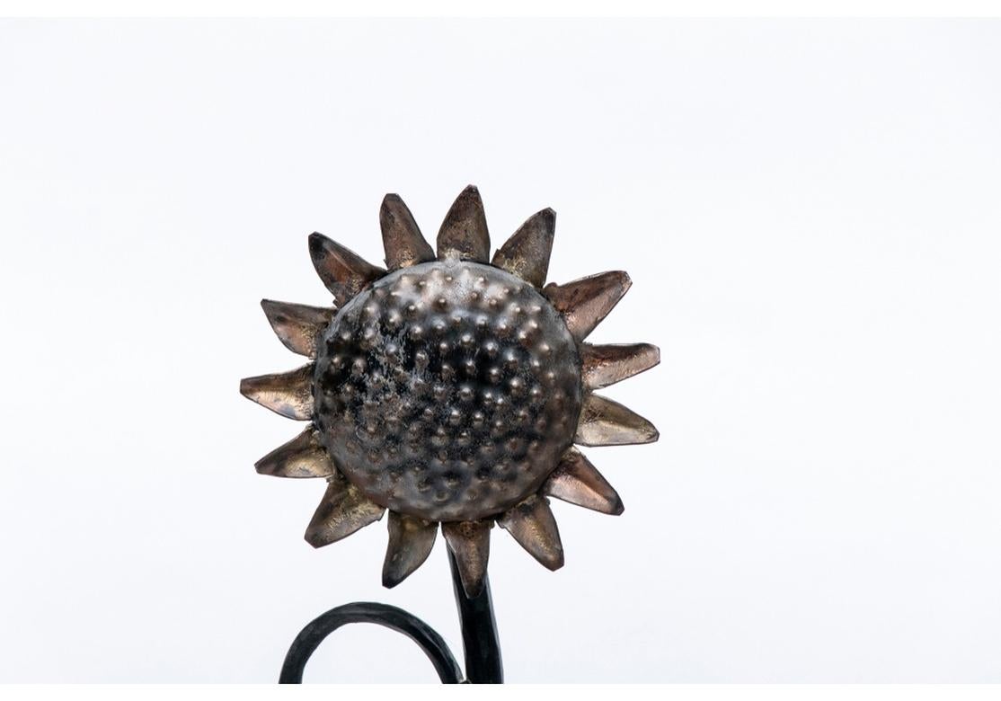 A very well crafted pair of Stylized Sunflower form Andirons in forged Iron. The pair have a lively animated rhythm and are reminiscent of the fantastic furniture and lighting designs of the renowned Swiss artist Diego Giacometti. There is an “H”