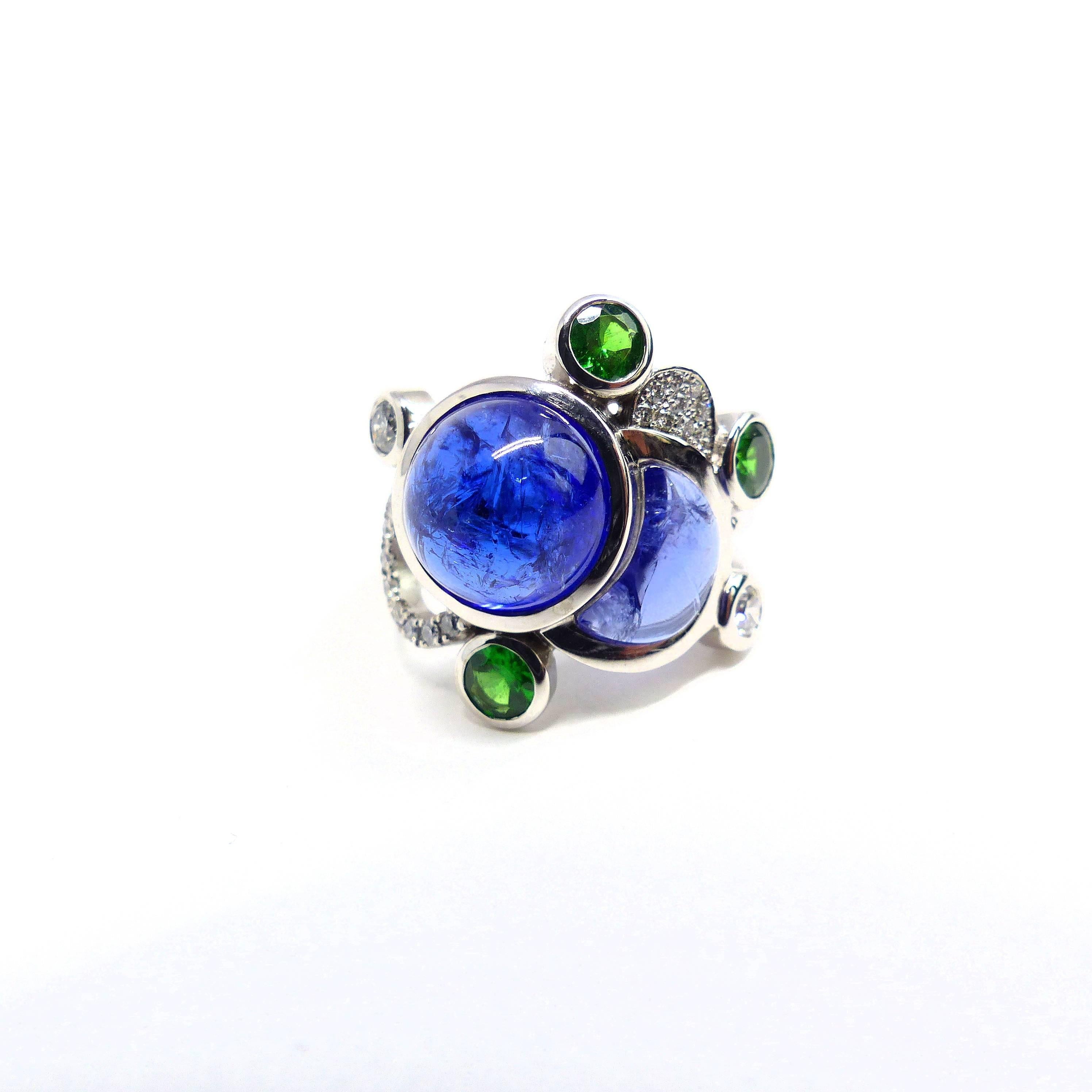 Thomas Leyser is renowned for his contemporary jewellery designs utilizing fine gemstones. 

This 18k white gold (11.44g) ring is set with 2x Tanzanite Cabouchons (round, 11mm) + 1x fancy cut (8,26ct) + 3x Tsavorites (brillant-cut, 4mm, 0.81ct) + 2x