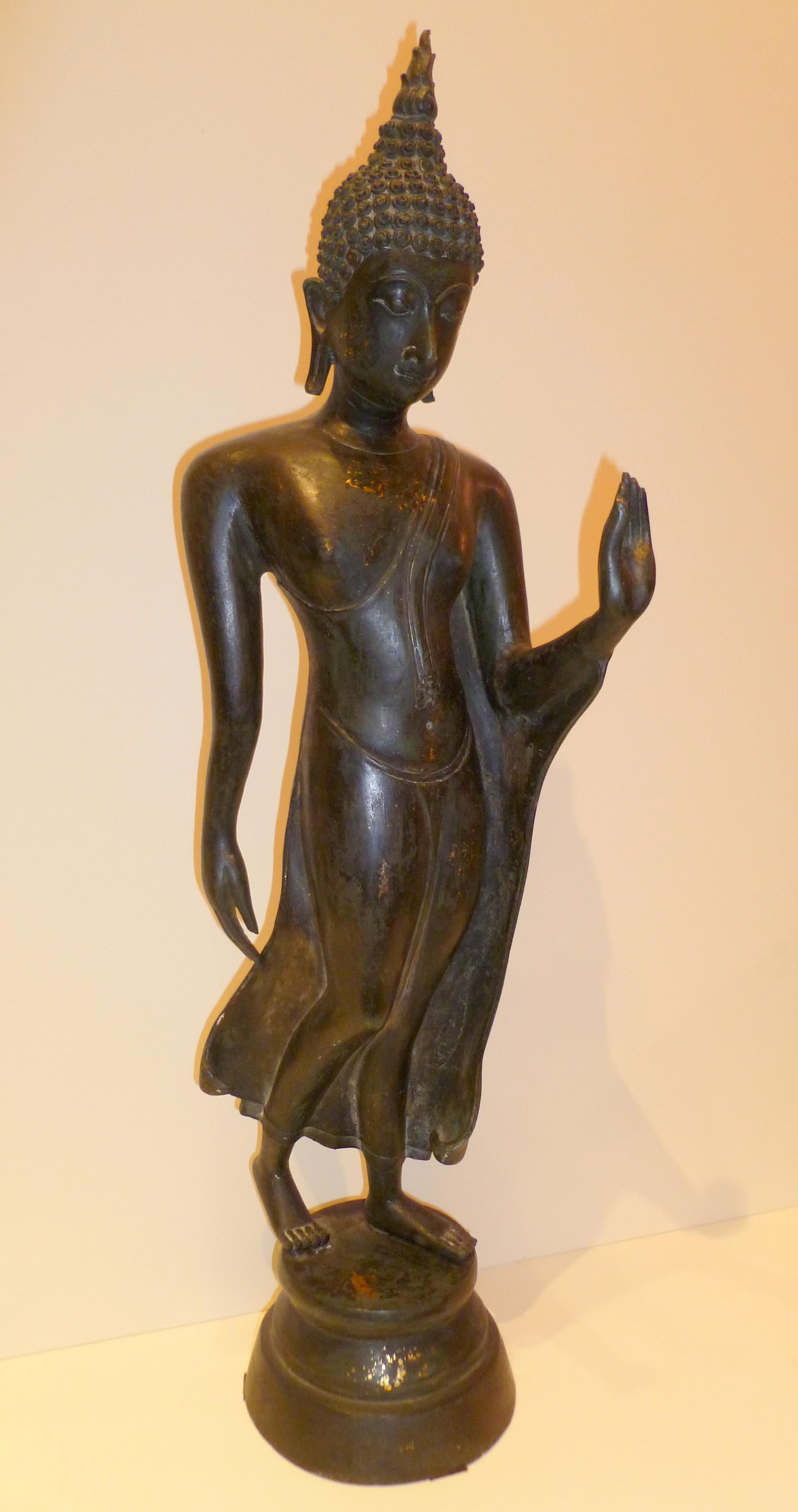 Thai standing bronze Buddha, benevolent facial expression, beautiful form and lines.
