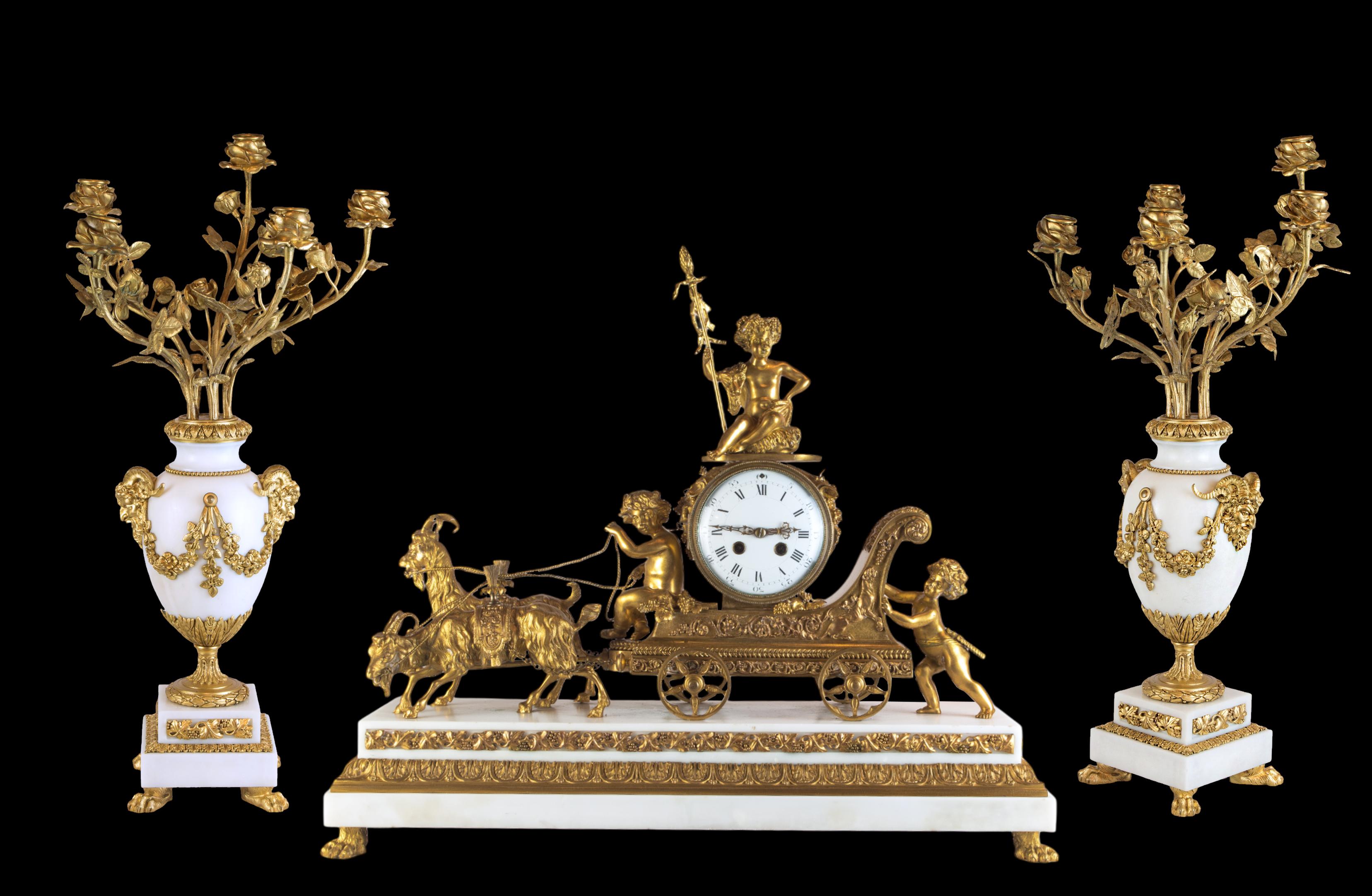 A fine antique French Gilt bronze and white marble garniture set of three putti playing in Thor's chariot. Rendered in crisp and bronze, a pair of Rams in dynamic poses pull the chariot, which we know belongs to Thor, as he is depicted and known for