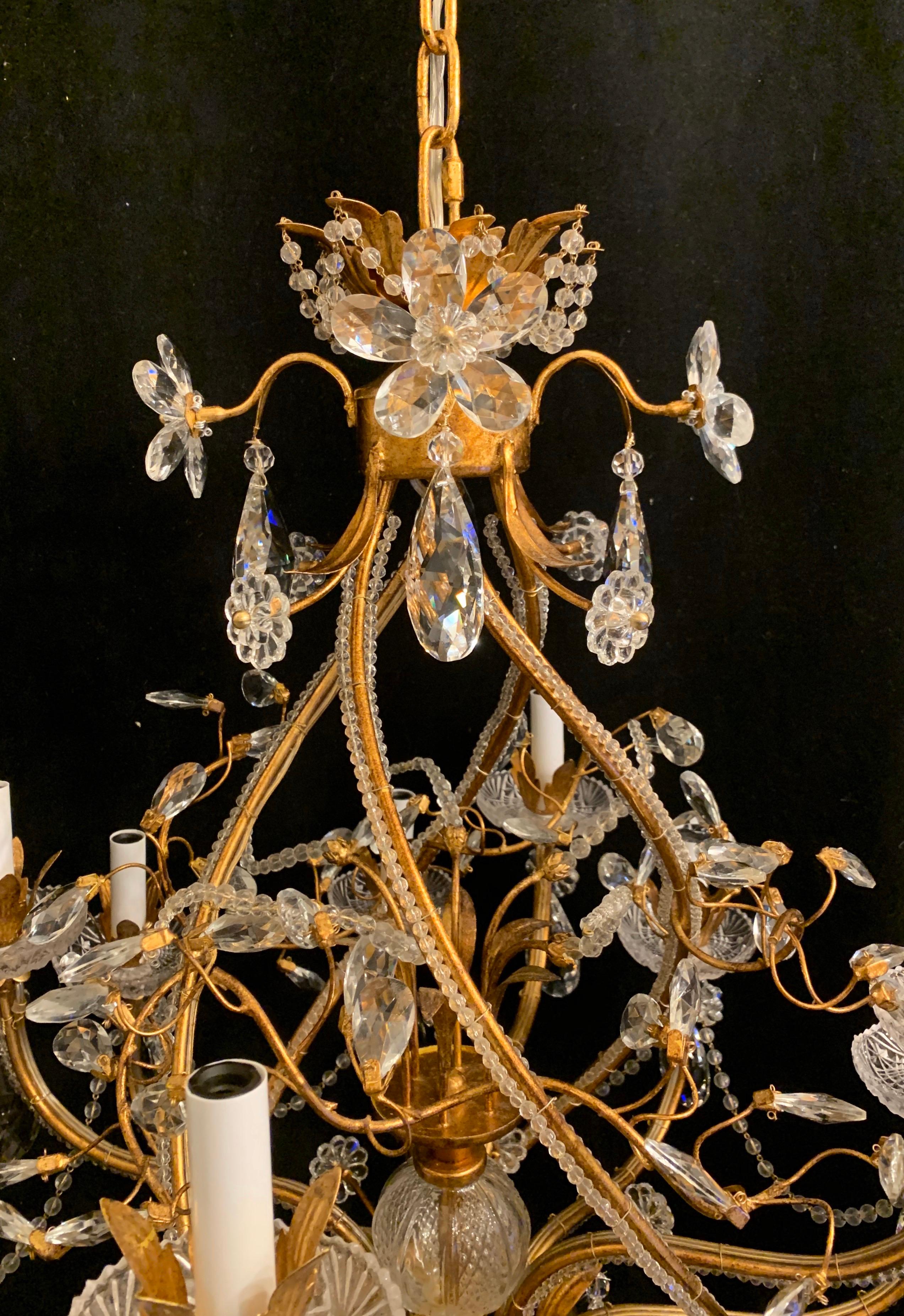A wonderful transitional Baguès / Jansen style 12 candelabra light gold gilt crystal beaded Swags, flower and crystal drops on a spiral form chandelier.