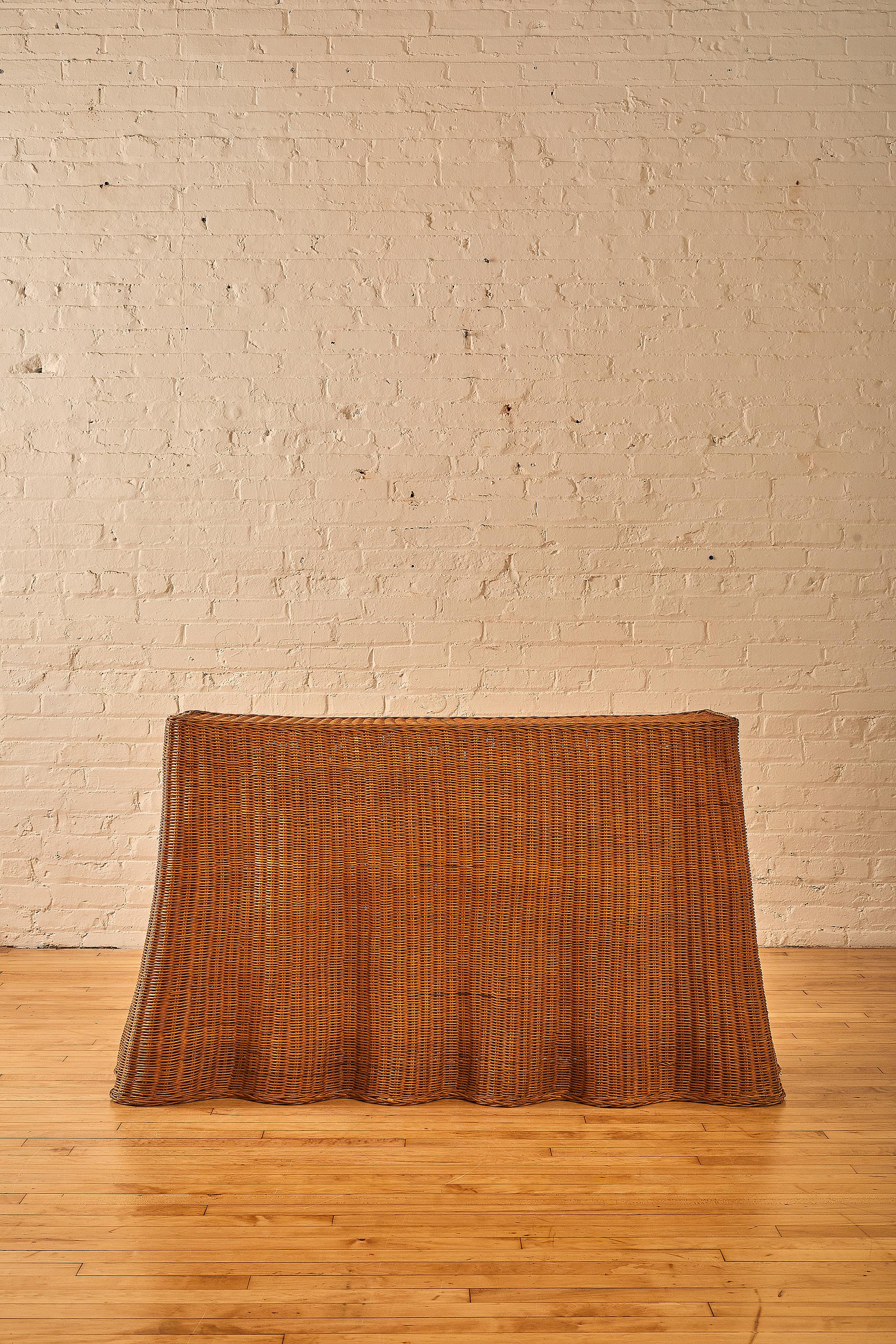 A fine wicker console table with a billowing drape on the bottom edge.

