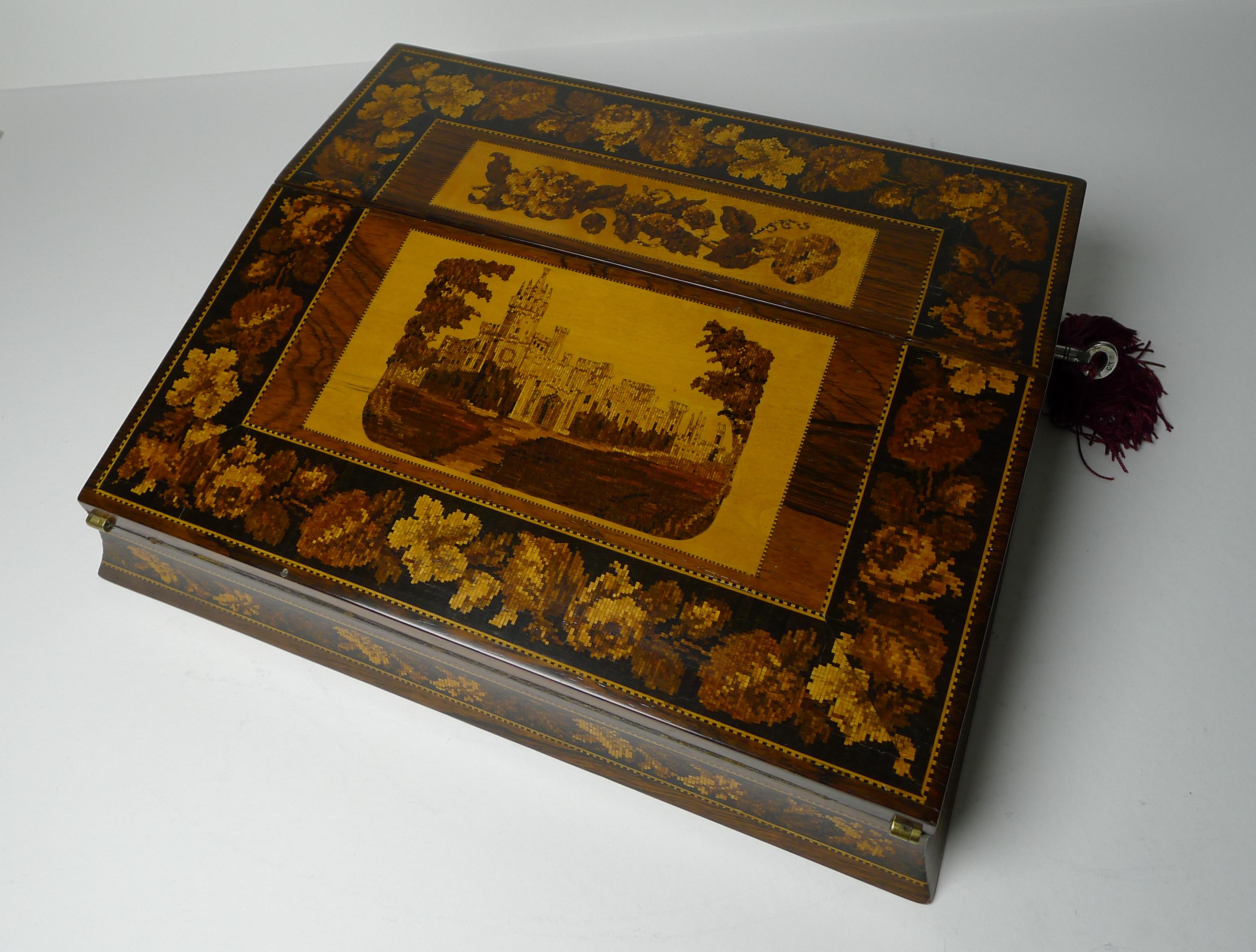 Ein wirklich schönes Beispiel eines viktorianischen Tunbridge Ware Schreibkastens oder Schoßschreibtisches aus der Zeit um 1870.

Der Mittelteil zeigt Eridge Castle, East Sussex.  Das Kästchen wird komplett mit einem funktionierenden Schlüssel mit