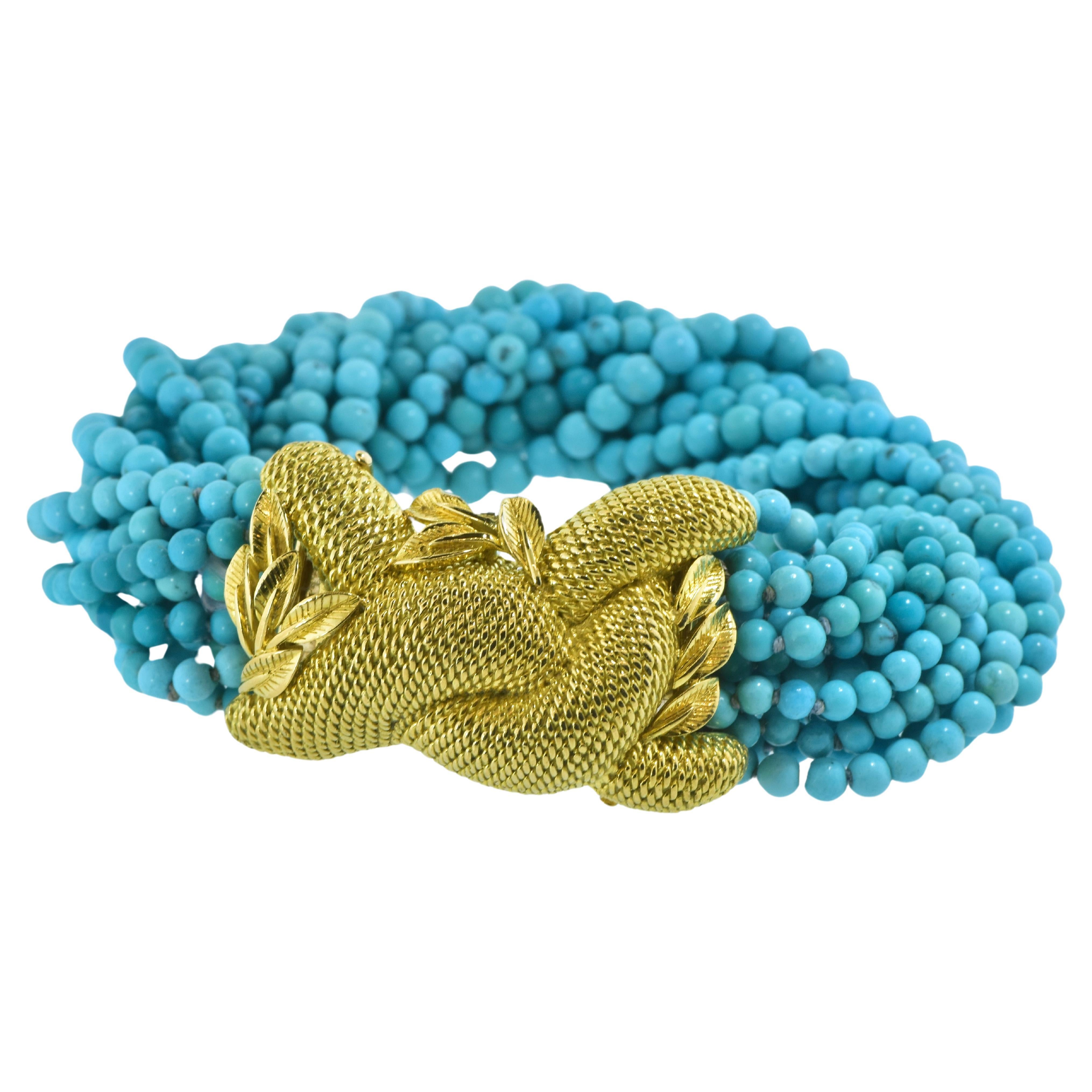 Fino brazalete estilo torsade de turquesa y oro amarillo de 14 quilates fabricado hacia 1965.    Esta pulsera torsade 16 vueltas  puede retorcerse de modo que su longitud oscile entre 15 cm y 15 cm.  Cada una de las 16 hebras de turquesa azul fina