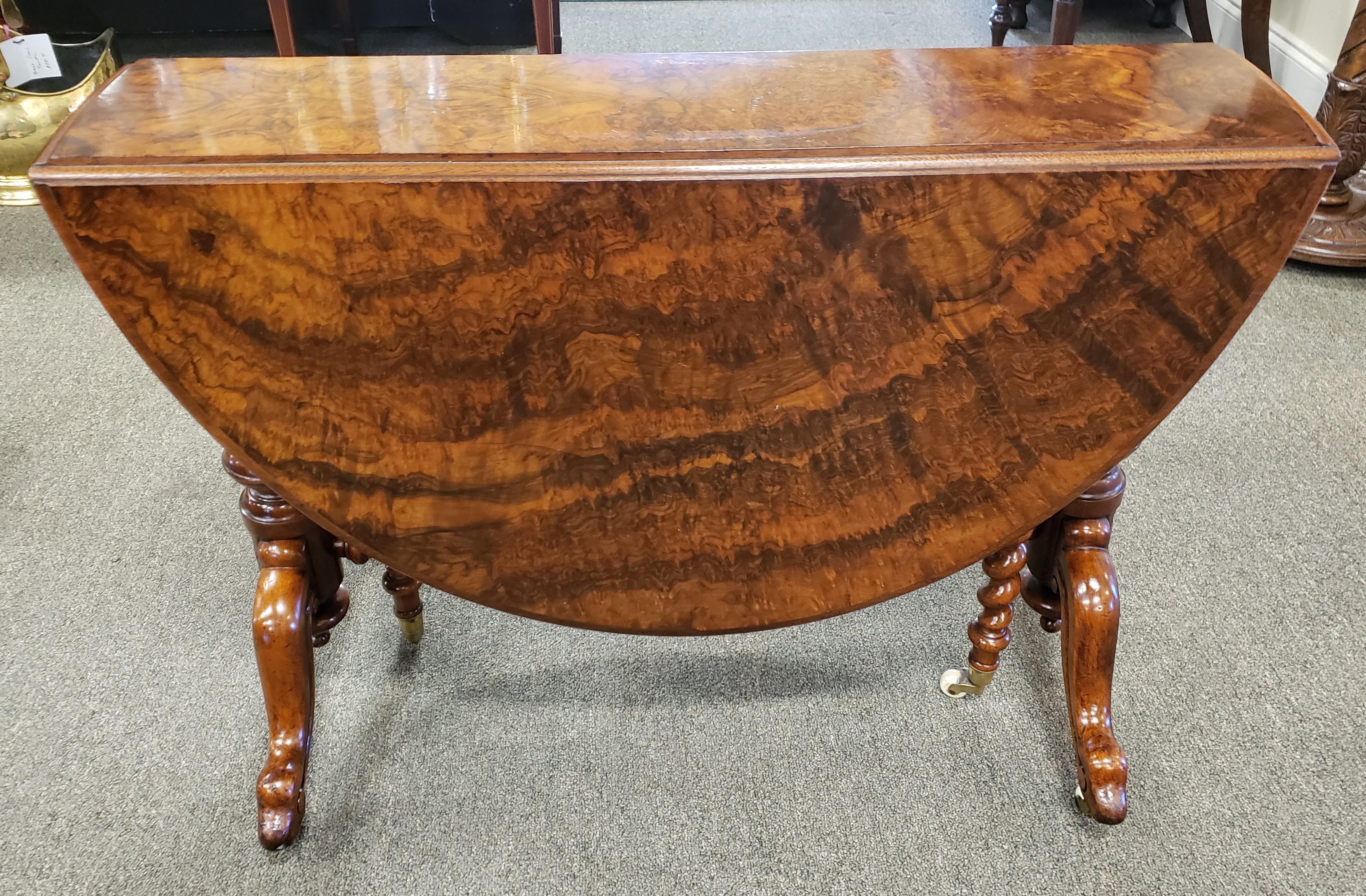 Fine Victorian burl walnut Sutherland table. Barley twist legs and stretcher. Castors on the bottom of the legs. The dimensions given are with the table open. The dimensions of the table closed are 8.5