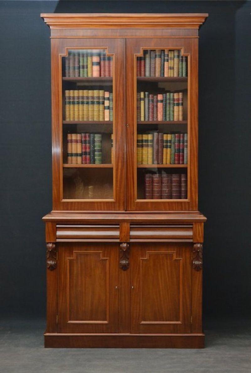 Sn3533 fine and elegant Victorian bookcase in mahogany with moulded cornice above a pair of glazed doors enclosing 3 height adjustable shelves, projecting base with two cushion shaped drawers and a pair of panelled cupboard doors, flanked by drop
