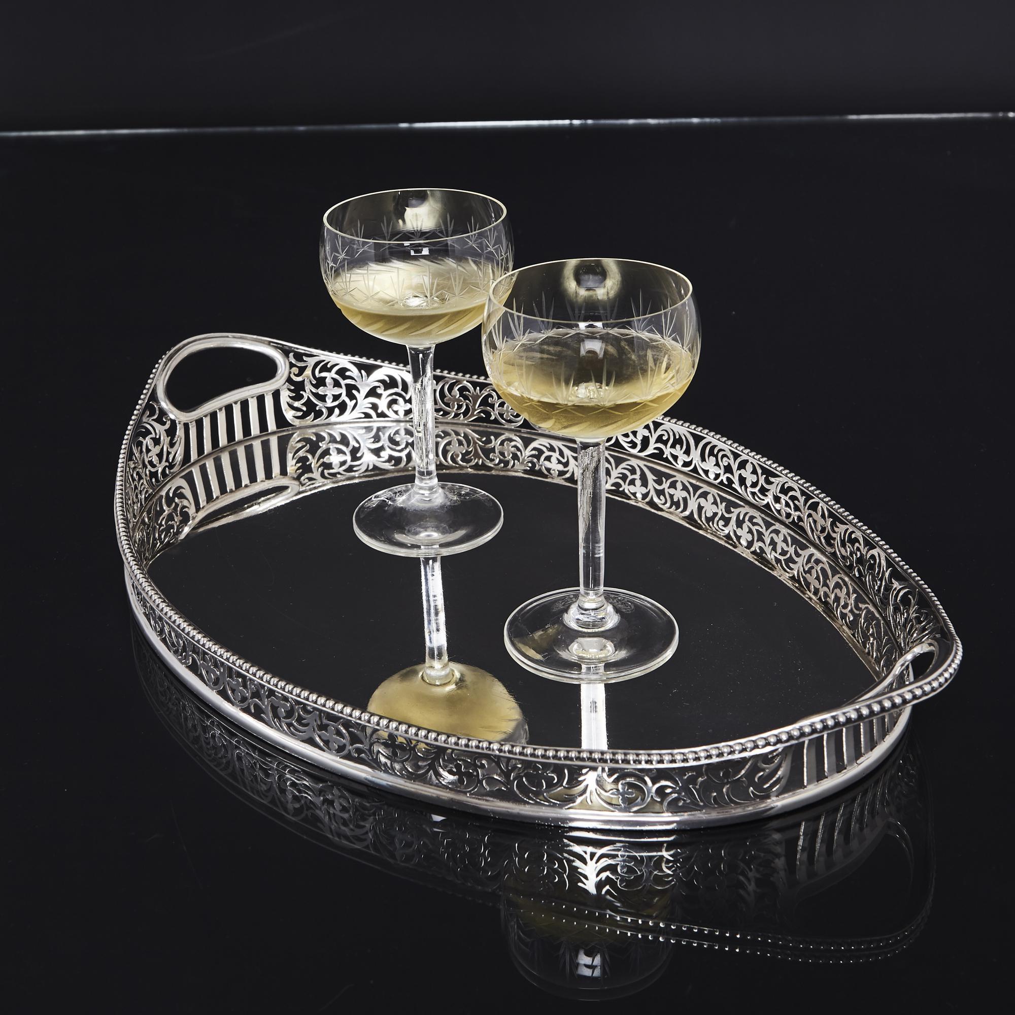 A fine quality antique sterling silver gallery tray of oval form, with a beautifully hand-pierced border. This elegant pattern incorporates a scrolling foliate design and is finished with a crisp bead edging. The handles are cut from the gallery and
