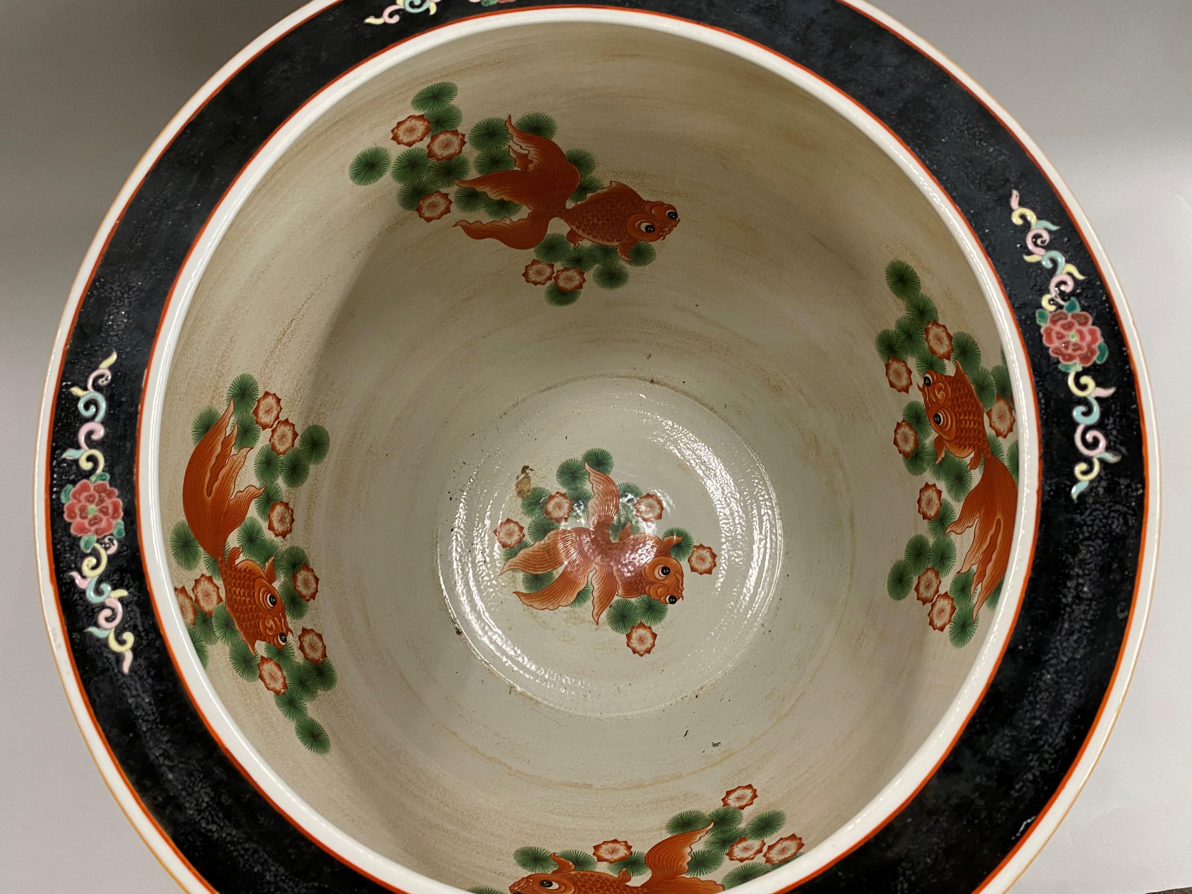 A beautifully decorated vintage Chinese polychrome hand painted porcelain jardinière or palace bowl with a variety of bird, animal, and foliate decoration around the exterior and rim, along with geometric decoration around the base rim, and koi