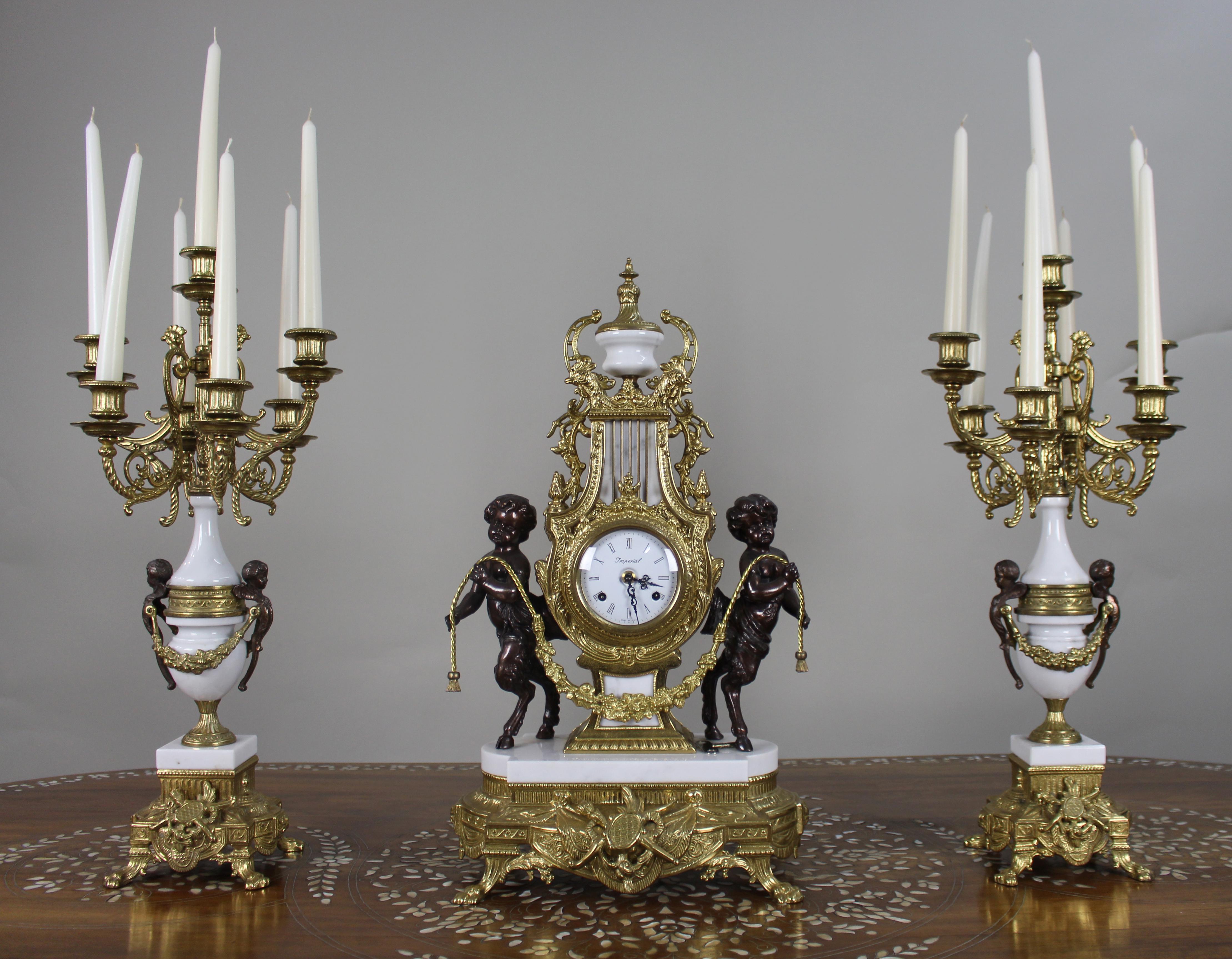Raffinato set di orologi da tavolo in marmo e bronzo d'epoca

Set decorativo di tre pezzi, realizzato in Italia per Imperial e dotato di un movimento tedesco Hermle a 8 giorni, fine del XX secolo.

L'orologio da camino centrale è formato da una lira