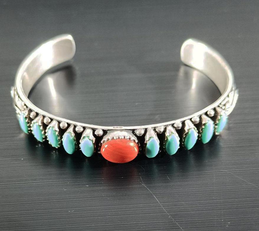 Un pregiato Navajo d'epoca, nativo americano.  bracciale A. Silver Gioielli in turchese

Un braccialetto sottile ed elegante di alta qualità con turchesi e coralli e decorazioni floreali in argento.

Circa anni '70 
6 x 1 x 55 cm circa peso 30