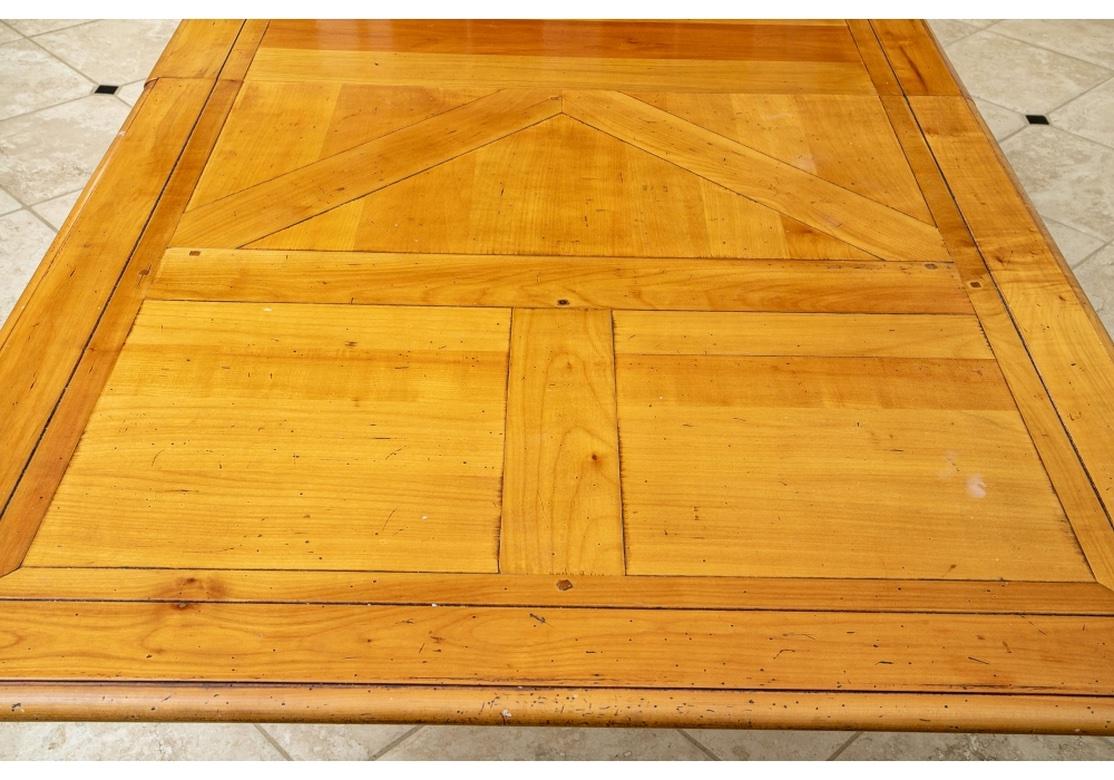 Une très belle table de style campagnard français de Pierre Deux. Construction fine à tenons et mortaises avec un dessus en surplomb incrusté de bandes. Il repose sur des pieds cylindriques tournés en anneau, avec un brancard en H sur des pieds