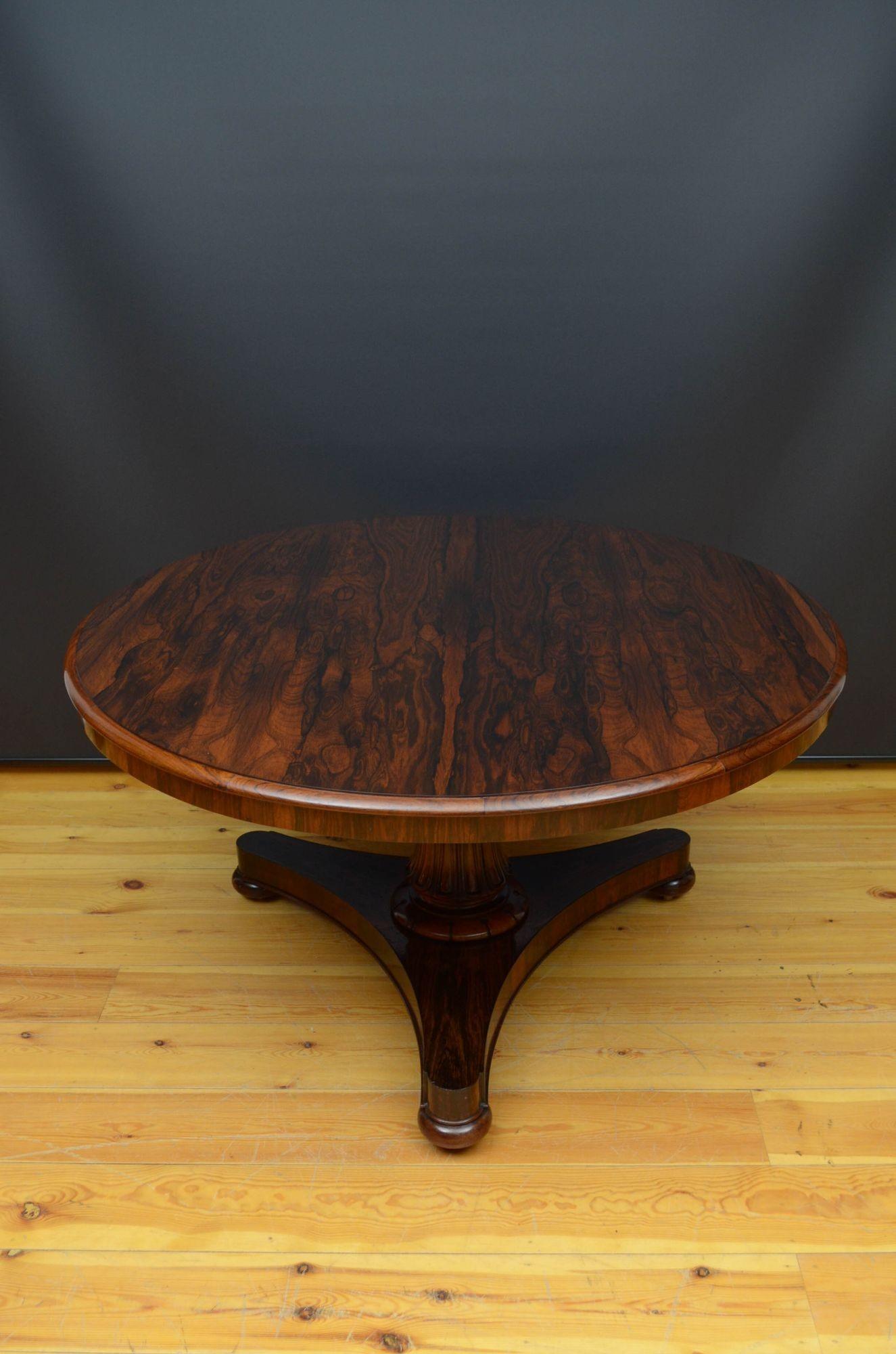 Sn5342 Fine William IV rosewood dining table or centre table, having tilt top with fantastic rosewood grain, standing on turned column with fluted decoration and carved collar terminating in trefoil base, bun feet and castors. This antique table is