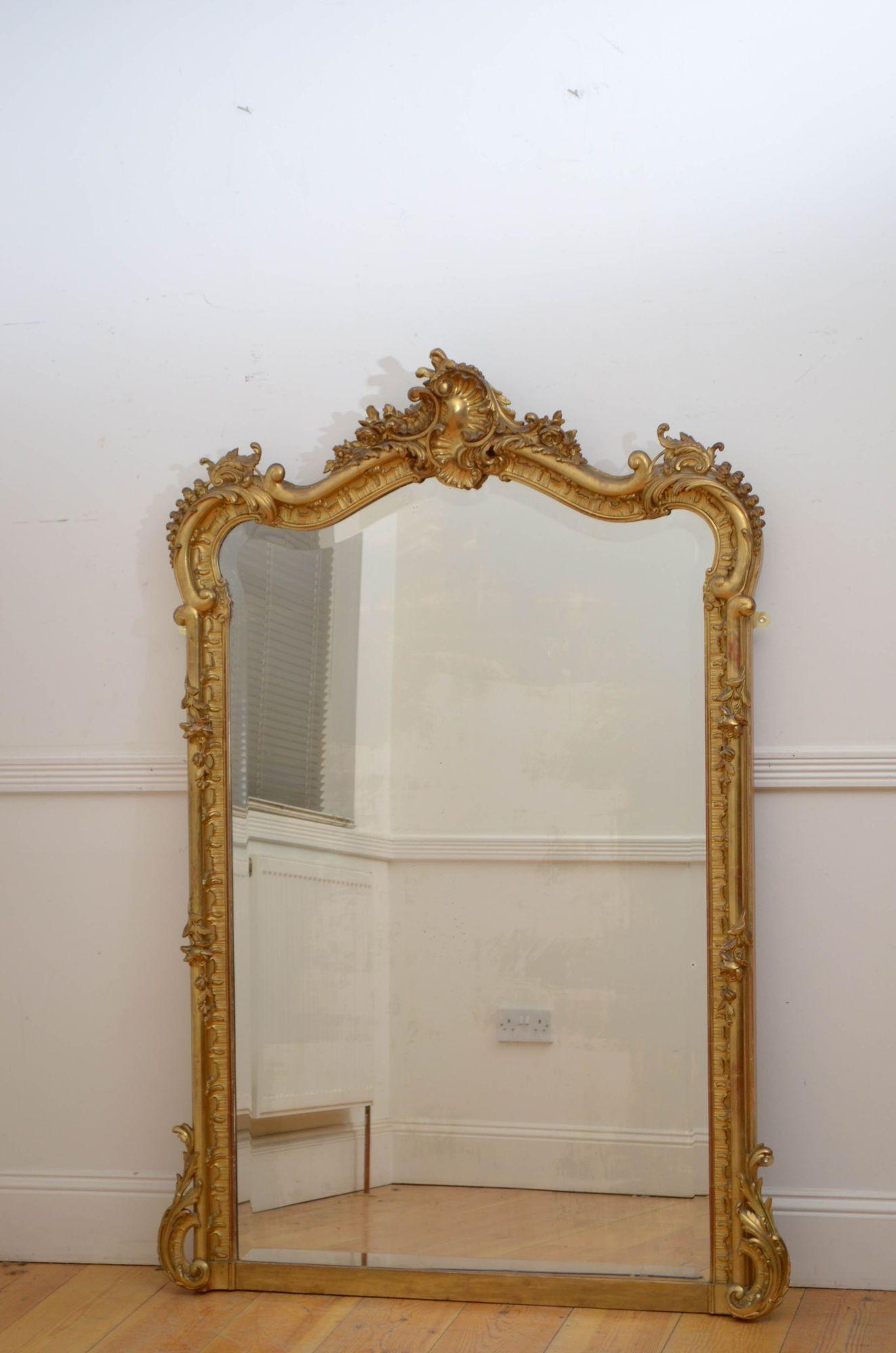 Sn5479 Superb 19th century French gilded wall mirror, having original bevelled edge glass with some imperfections in moulded, scallop carved and gilded frame with shell centre crest flanked by floral and leaf motifs and foliage scrolls to the base.