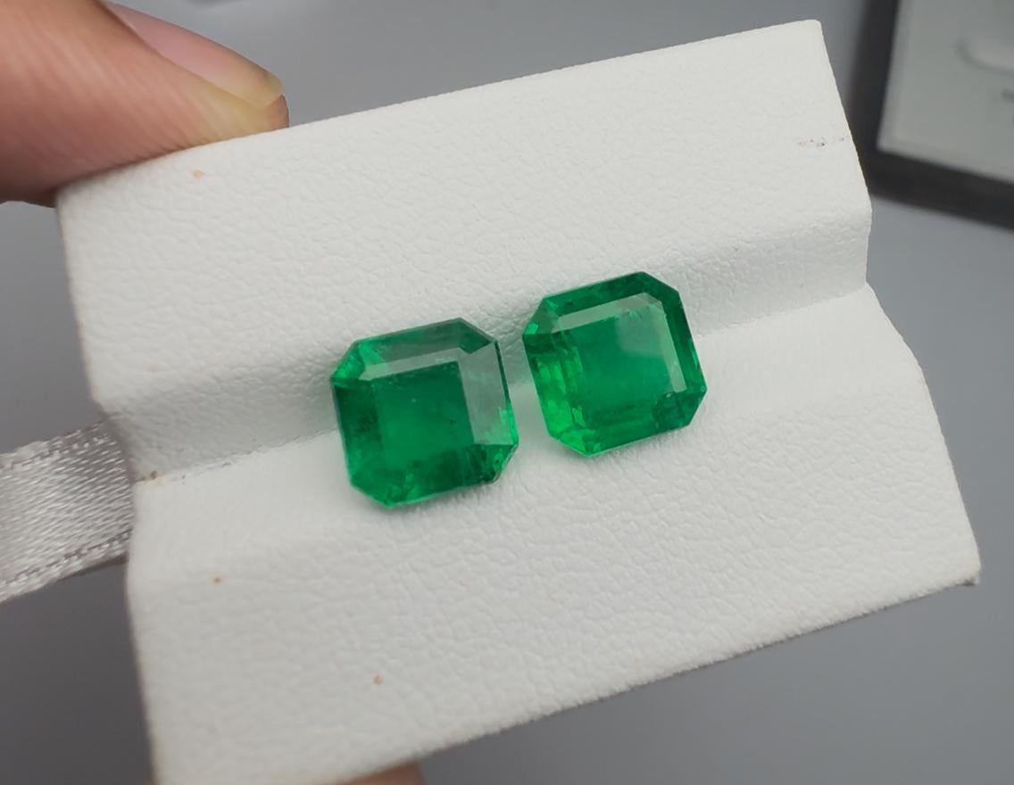 This refined 5.75 carat matching pair of square-cut Emeralds has been meticulously selected for its exceptional harmony in color, clarity, and overall aesthetics. Both stones display a beautifully balanced medium-vivid green hue with smooth, even